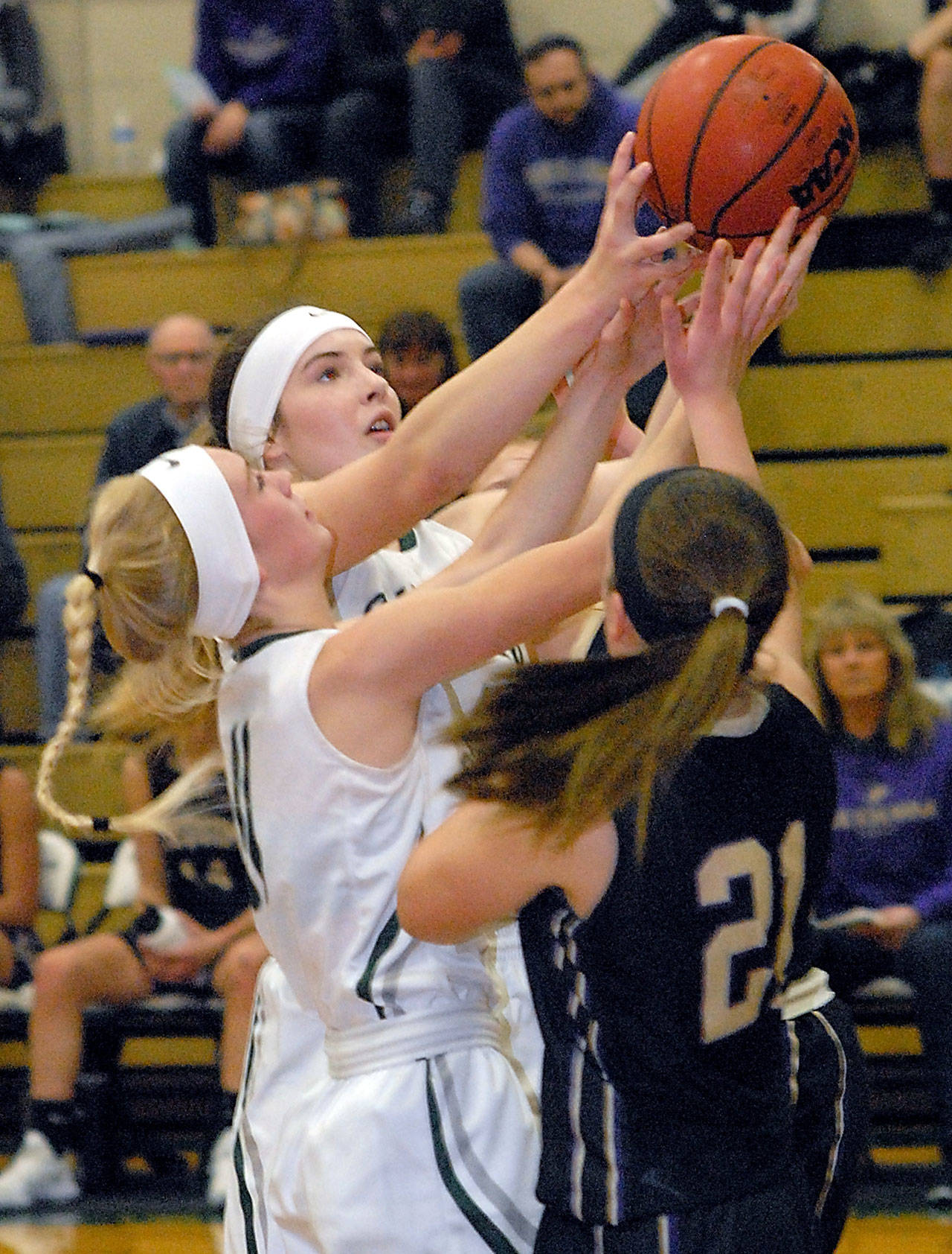 Keith Thorpe/Peninsula Daily News Port Angeles’ Gracie Long, left, and Devin Edwards, center, battle for a rebound with Sequim’s Kalli Wiker, right, in second-quarter play on Wednesday in Port Angeles.