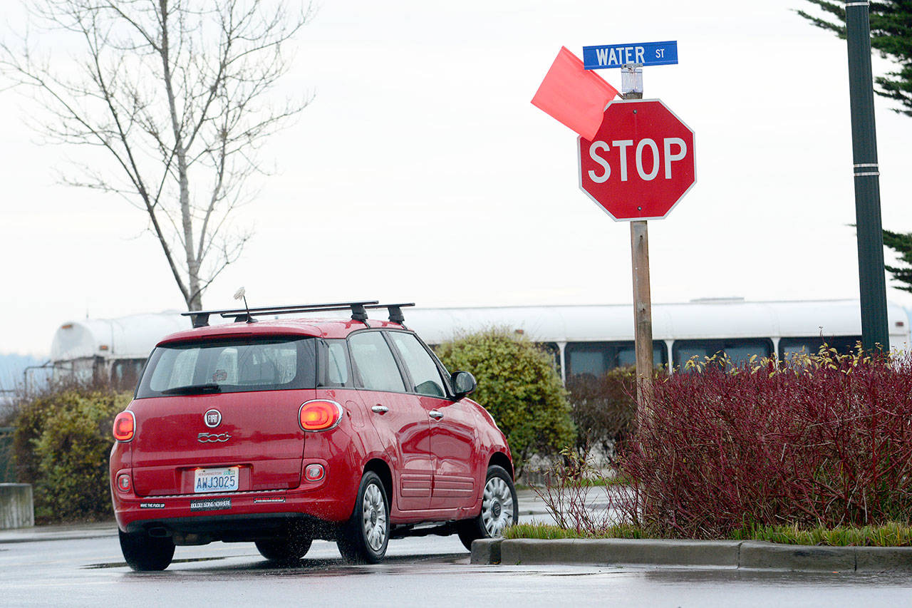 A driver turns right at a stop sign in Port Townsend. City crews removed signage from signs that allowed drivers to turn right at stop signs without stopping. (Jesse Major/Peninsula Daily News)
