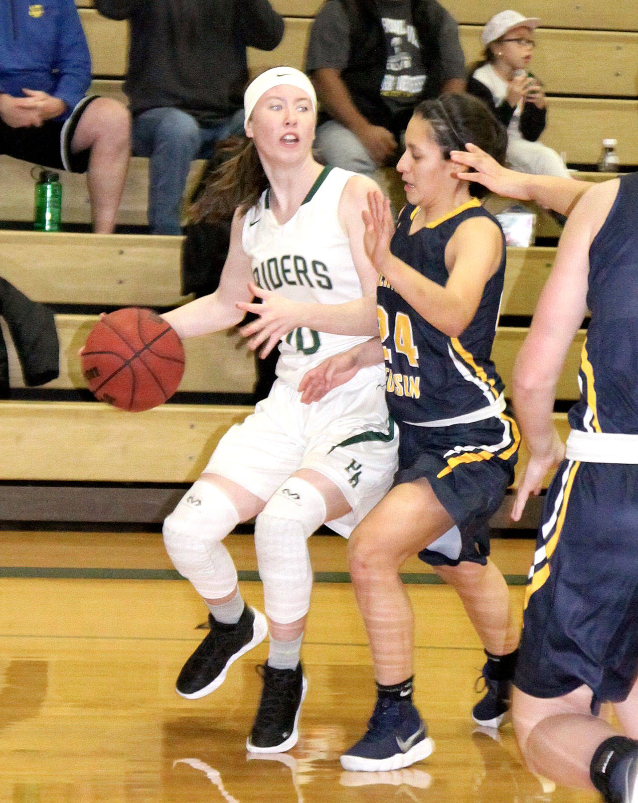 Port Angeles’ Mikkiah Brady looks to get past the defense of Burlington-Edison’s Annalies Reyes during the Roughriders’ 48-45 win Saturday. (Dave Logan/for Peninsula Daily News)