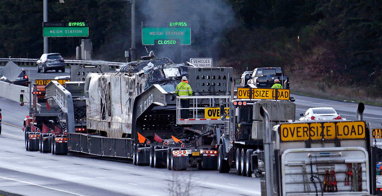 The engine from an Amtrak train that crashed onto Interstate 5 on Monday is transported away from the scene Wednesday in DuPont. (Elaine Thompson/The Associated Press)