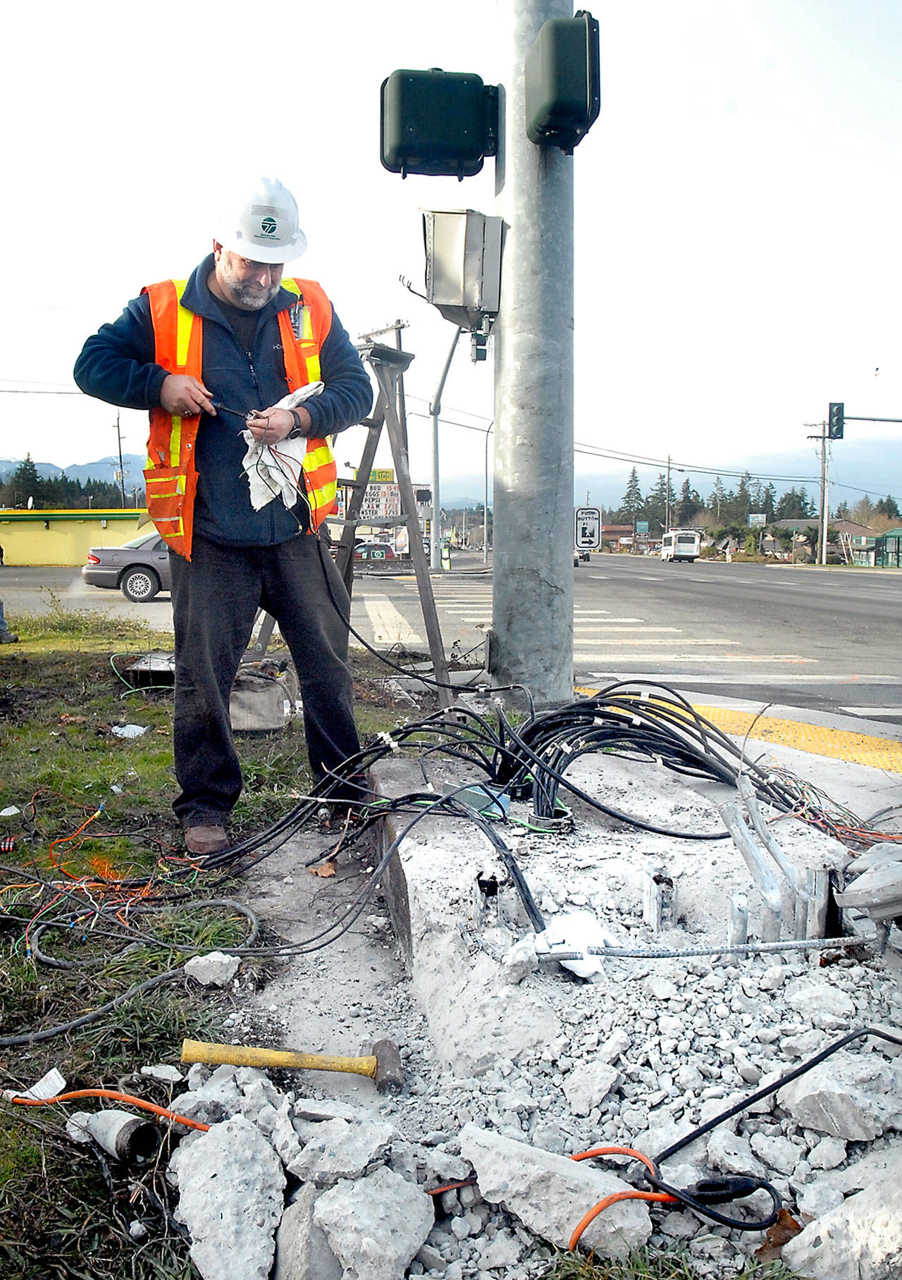 Robb Reese, a transportation technician for the Washington State Department of Transportation, works to repair the wiring to a traffic light control box at the intersection of U.S. Highway 101 at Mount Pleasant Road that was destroyed in a traffic wreck Thursday morning near Port Angeles. (Keith Thorpe/Peninsula Daily News)