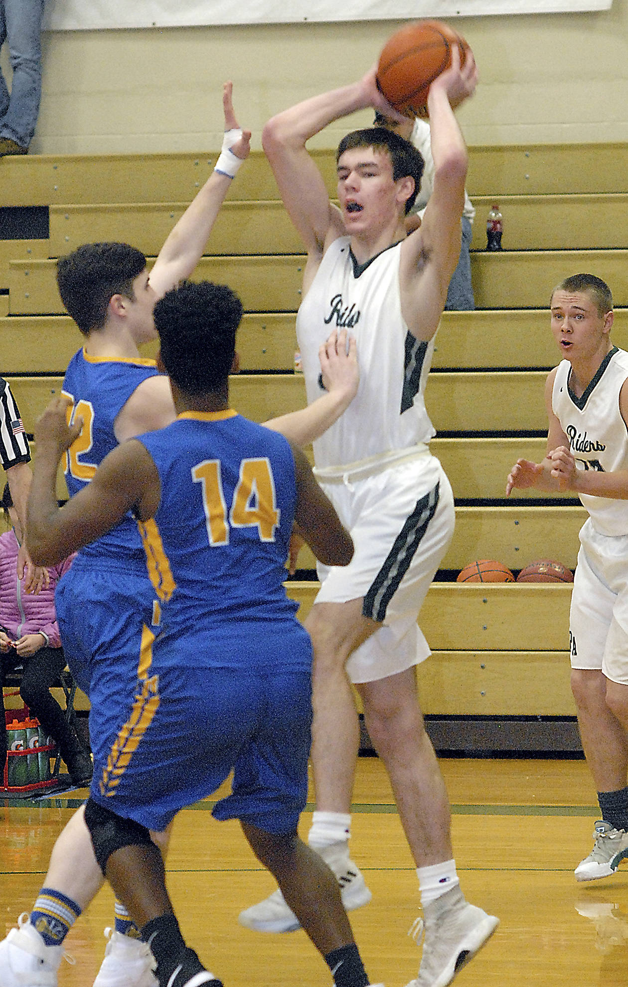 &lt;strong&gt;Keith Thorpe&lt;/strong&gt;/Peninsula Daily News                                Port Angeles’ Liam Clark, top, looks to pass over the heads of Rochester’s Jarrett Smith, left, and Stephen Robinson Friday during the first round of the Port Angeles Holiday Basketball Tournament. Looking on at right is Port Angeles’ Easton Joslin.