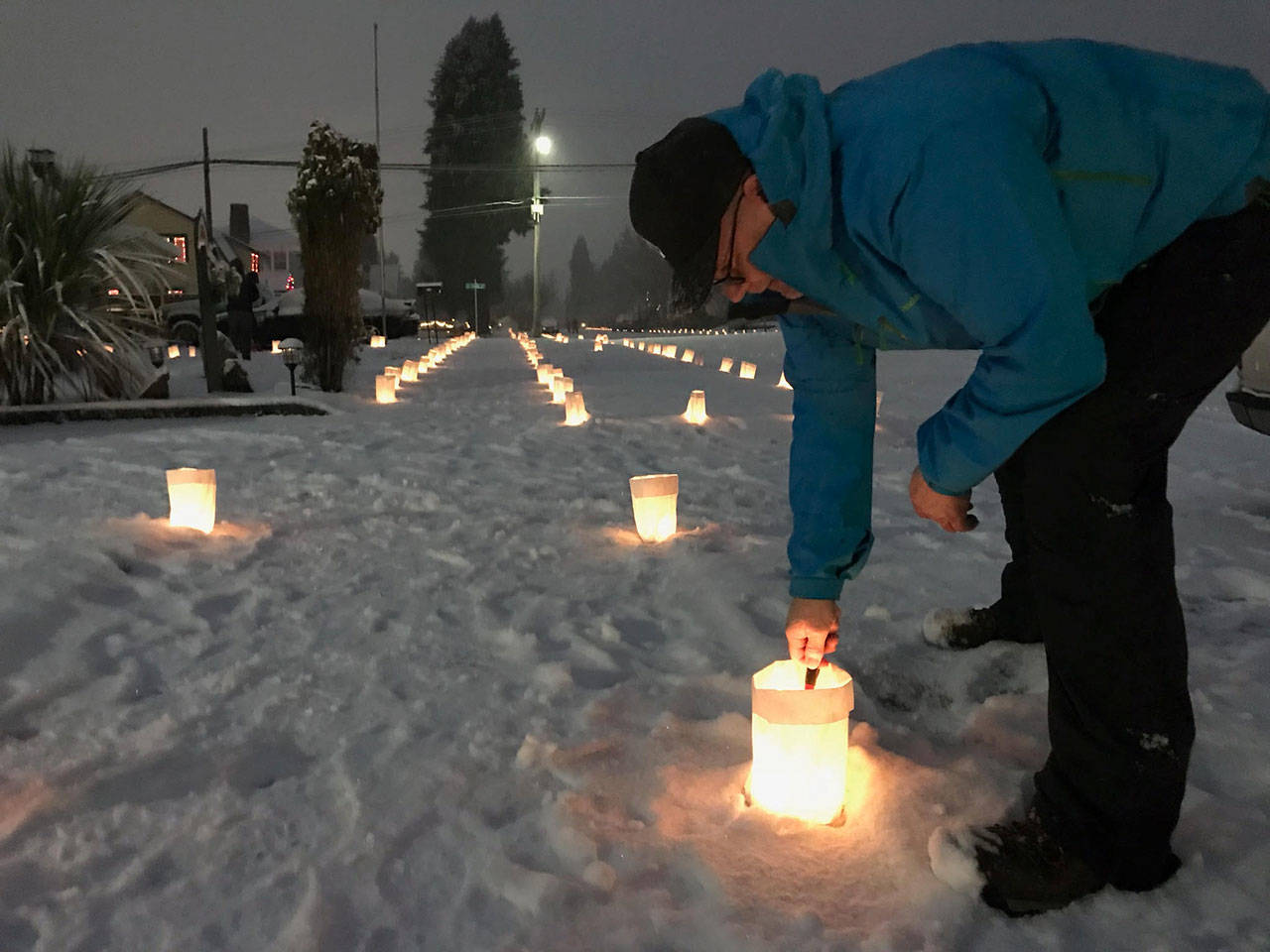 Pat Bartholick joined others in his East Second Street neighborhood in Port Angeles on Christmas Eve to light luminaries as part of a 40-year-old tradition. (Paul Gottlieb/Peninsula Daily News)
