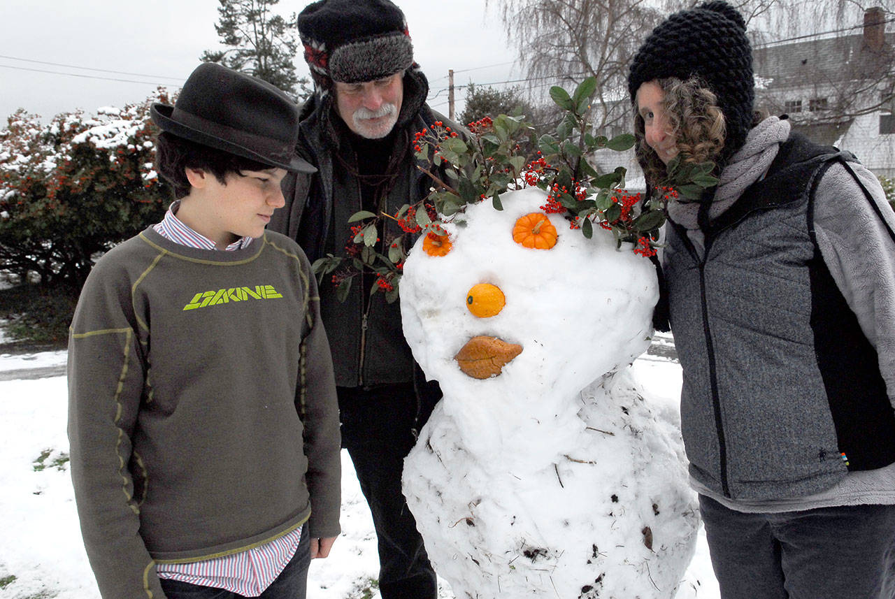 Oscar, Michael and Ruth Levine of Walker Street, Port Townsend, created a snowman for their neighbors as a Christmas surprise.They used volunteer plant material, repurposed Halloween mini-pumpkins, a squash and bread for lips. The project started out as a snowball fight and grew from there. (Jeannie McMacken for Peninsula Daily News).