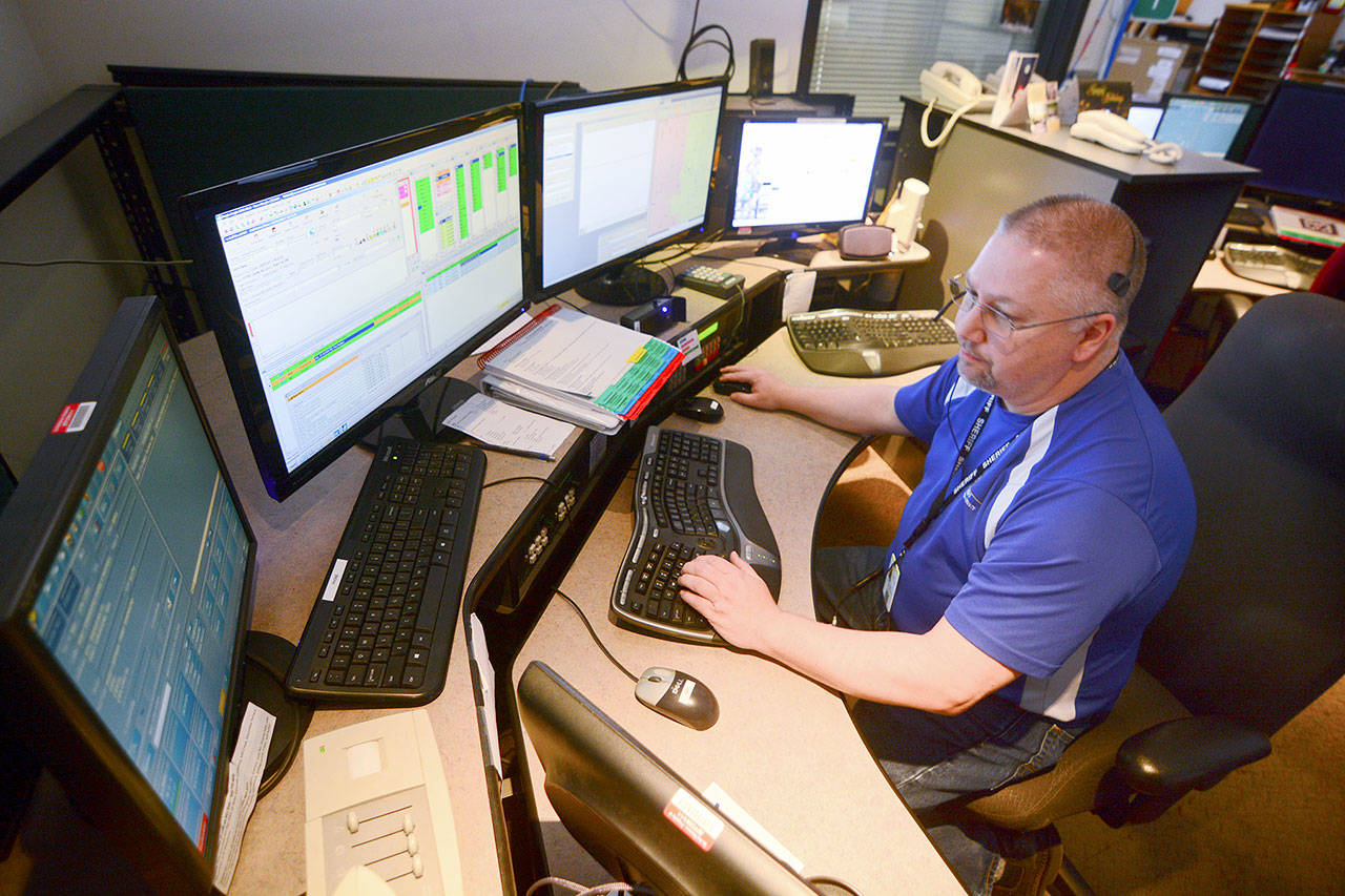 JeffCom Dispatcher Terry Taylor handles a call Tuesday amid a report of a possible capsized boat near the Hood Canal bridge. Calls from that area are frequently routed to the incorrect dispatch center. (Jesse Major/Peninsula Daily News)