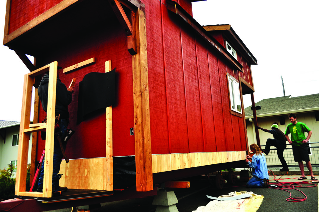 Peninsula College student carpenters work  on finishing the exterior of the mini-home they are building at the Lincoln Center in Port Angeles. Jesse Major/for Peninsula Daily News