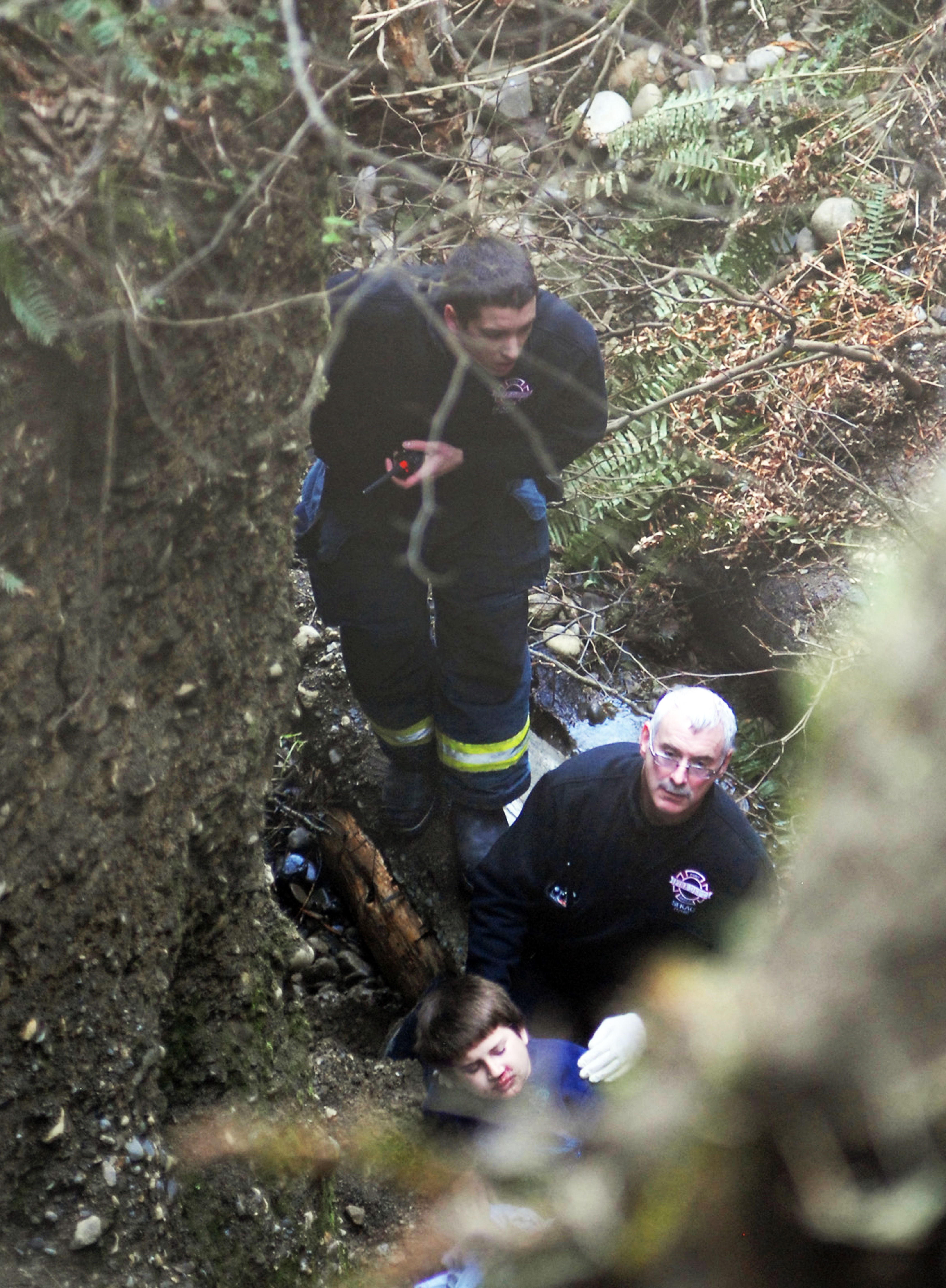 Rescue personnel stabilize the 9-year-old boy who fell over a bluff above the Nippon Paper Industries mill in west Port Angeles tonight. Chris Tucker/Peninsula Daily News