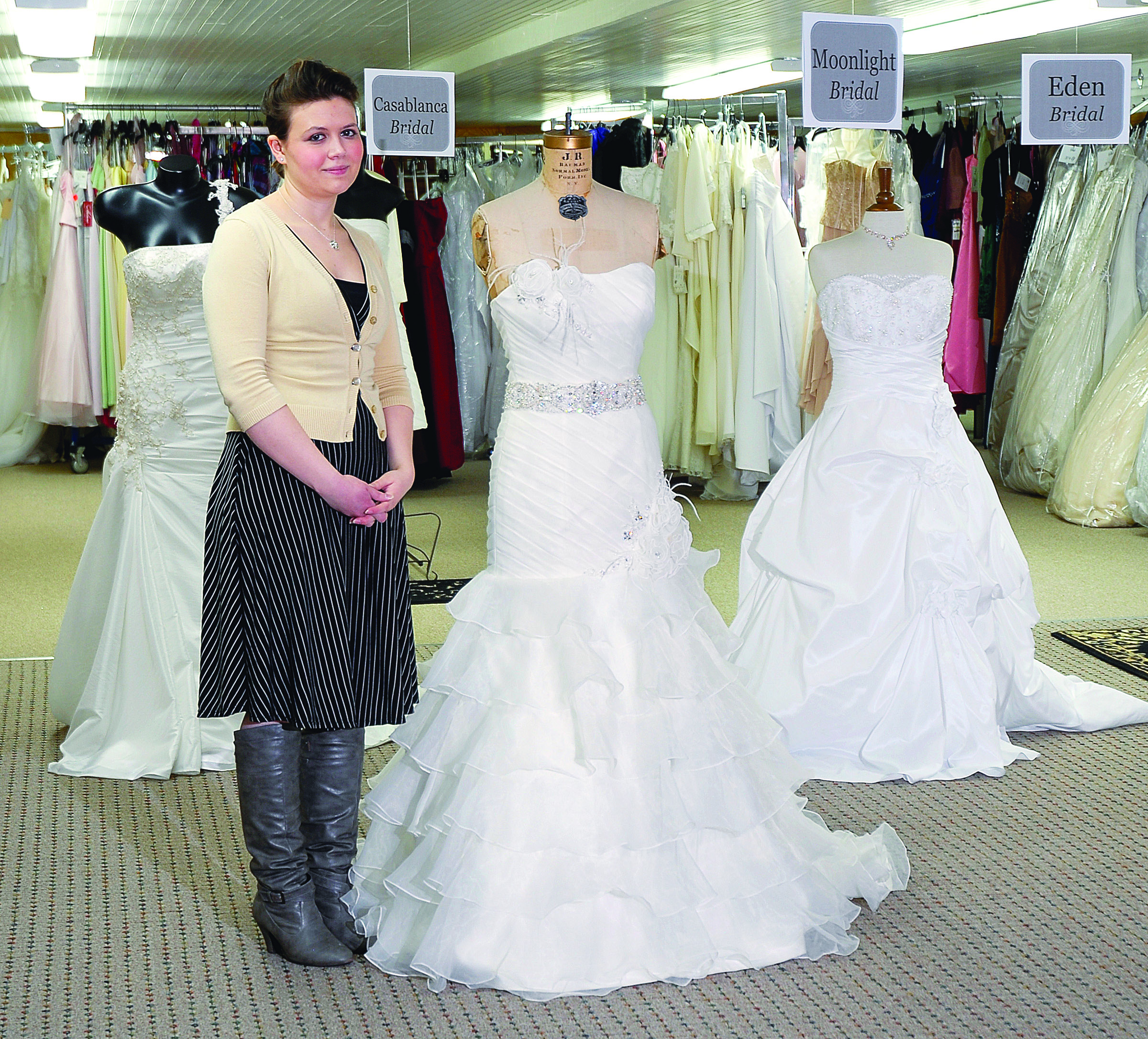 Black Diamond Bridal employee Jesseca Larson stands next to a dress from Moonlight Bridal on Wednesday. Chris Tucker/Peninsula Daily News