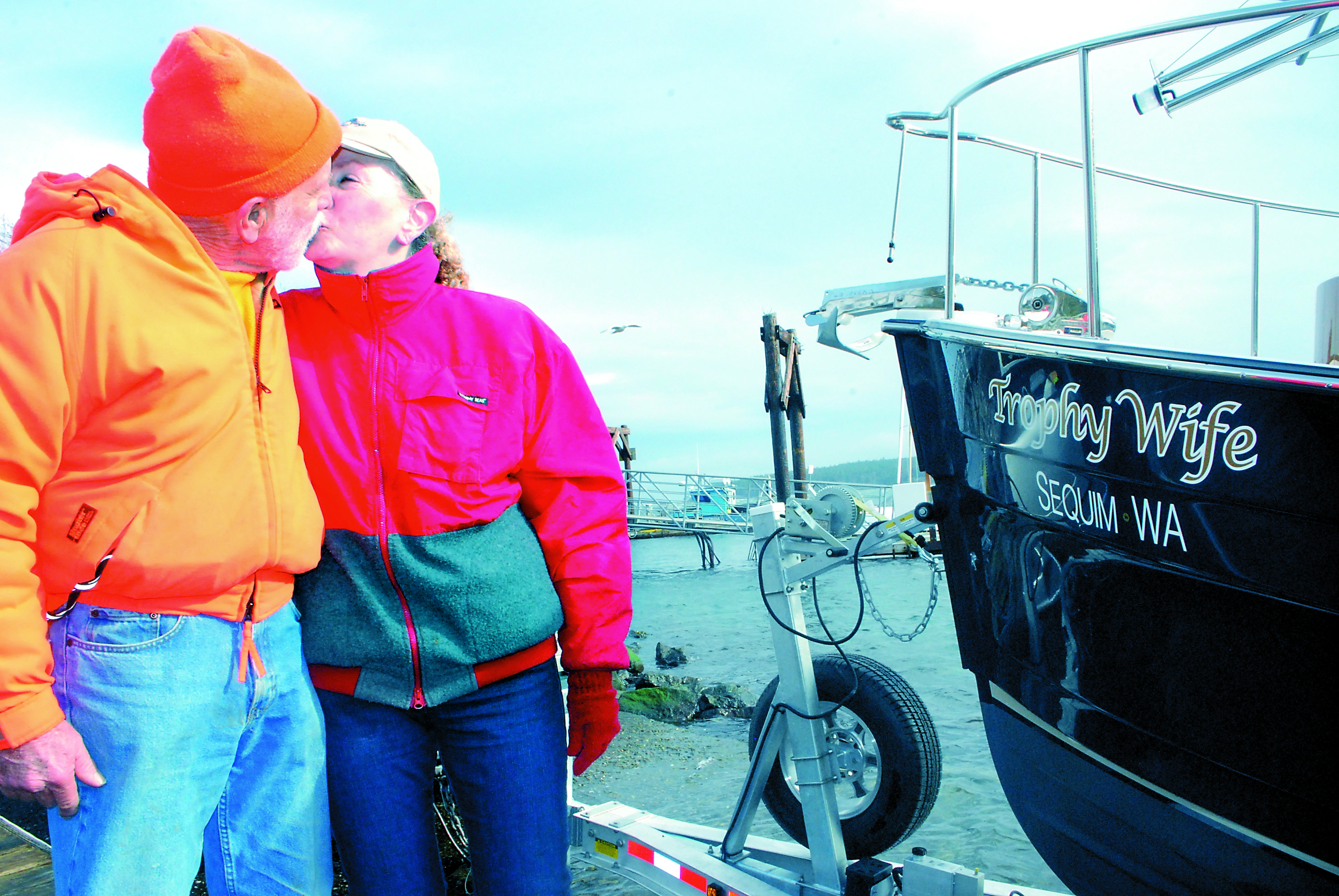 The Janises smooch in front of their new yacht at the John Wayne Marina in Sequim. Jeff Chew/Peninsula Daily News