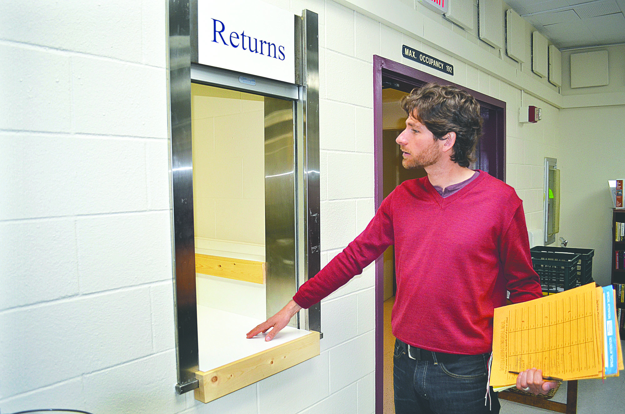 Librarian Keith Darrock inspects the return slot at the new temporary library in Mountain View Commons