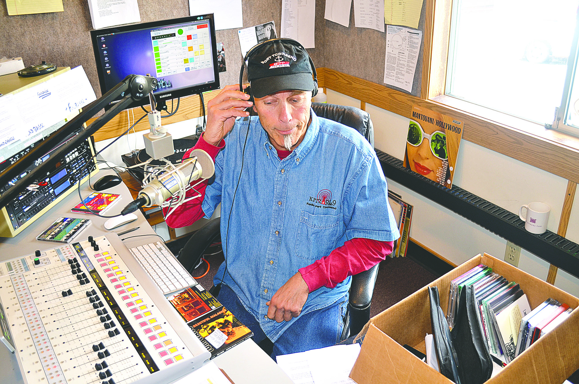 KPTZ DJ John Hulburd cues up a public service announcement at KPTZ on Wednesday in Port Townsend. Charlie Bermant/Peninsula Daily News