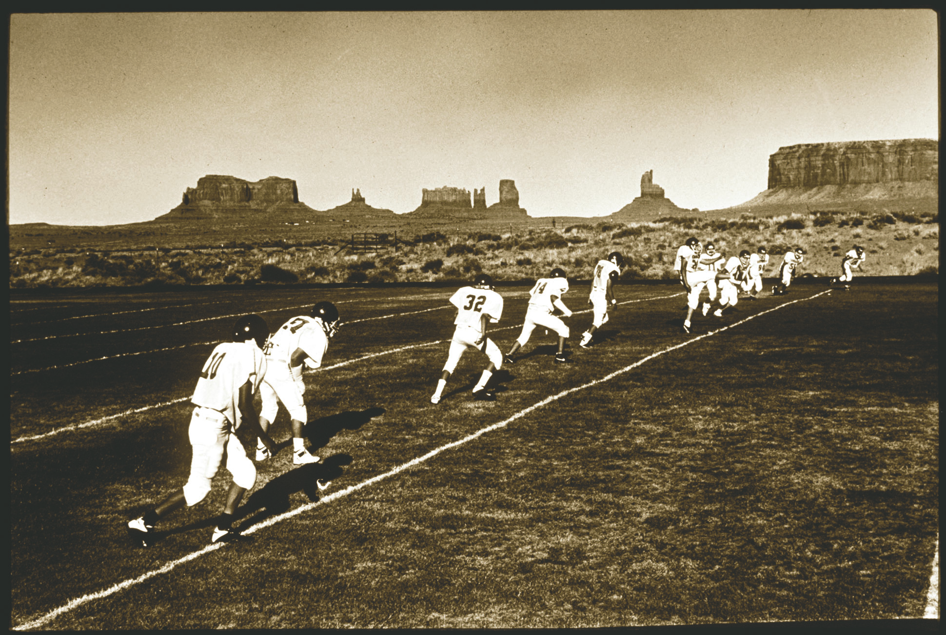 Members of the football team at Monument Valley High on the Navajo Reservation practice on their field with the famous buttes in the background. This is just north of the Arizona/Utah border. Alan Berner
