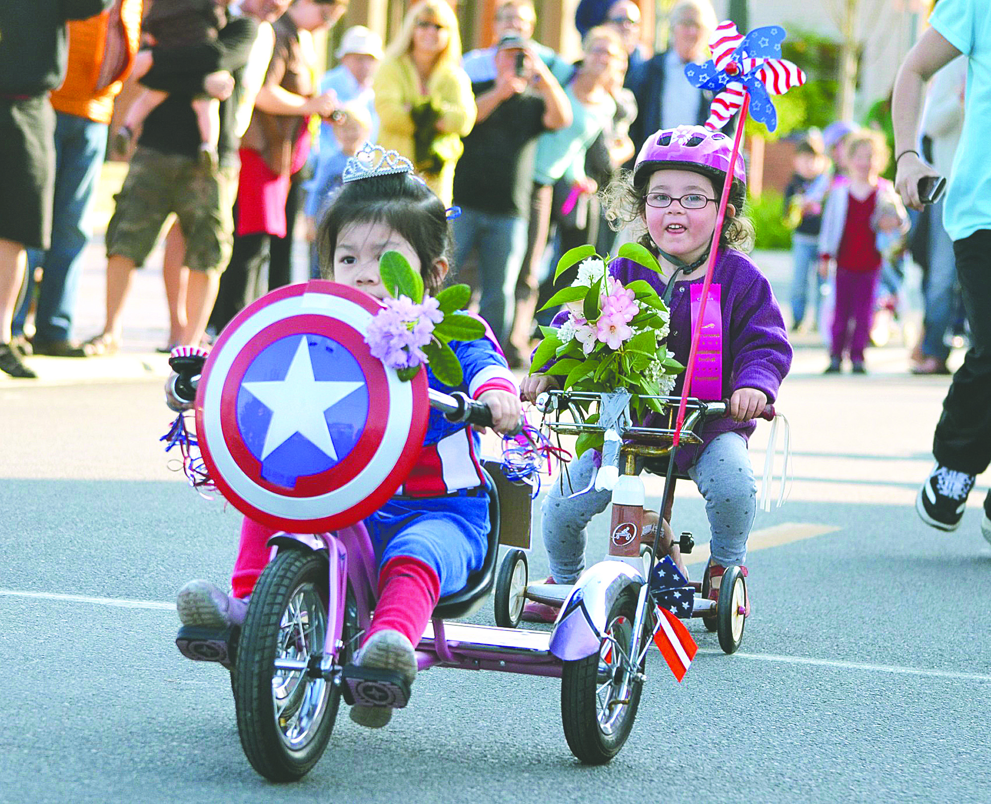 Livia Lee pulls ahead of Silja Sebastian in the 3-year-old segment of the 77th annual Rhododendron Festival's Trike Race on Water Street in Port Townsend on Wednesday. Charlie Bermant/Peninsula Daily News