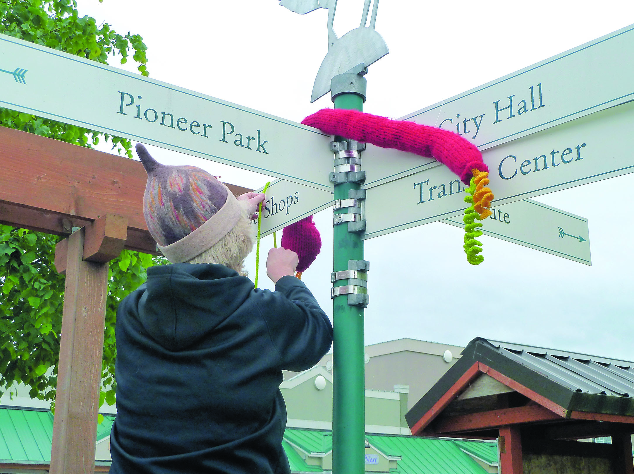 A  yarn bomber adorns a set of signs in downtown Sequim with a yarn snake. Fiber Arts Bombardiers