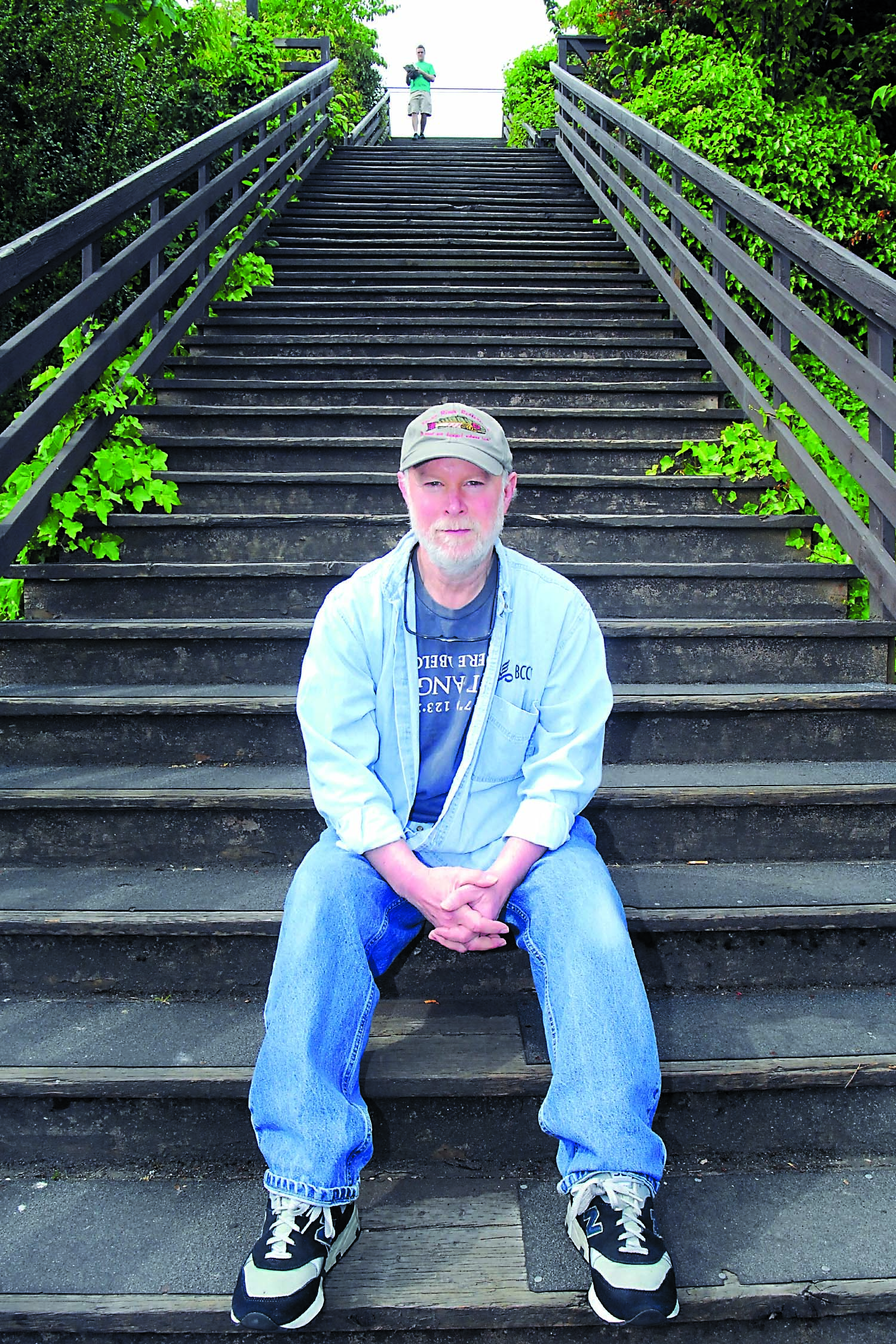 Alan Turner of Port Book and News sits on the stairs that ascend the bluff at Laurel Street behind the Conrad Dyar Memorial Fountain in downtown Port Angeles. Keith Thorpe/Peninsula Daily News