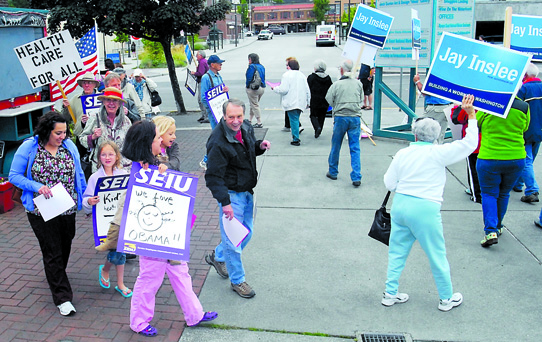 Supporters of the Affordable Health Care Act march in front of the Landing Mall in Port Angeles Thursday to celebrate the Supreme Court decision upholding the act. Washington Attorney General Rob McKenna