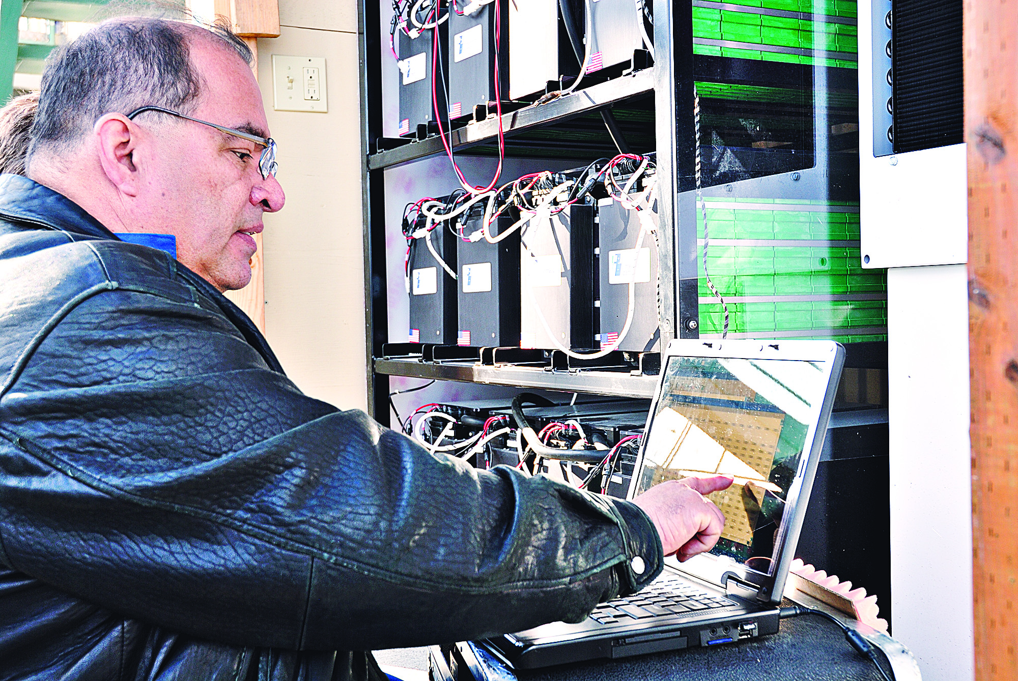 Bill Ayala with International Battery uses his laptop next to a shelf full of rechargeable lithium-ion batteries outside The Landing mall in Port Angeles.  -- Photo by Chris Tucker/Peninsula Daily News