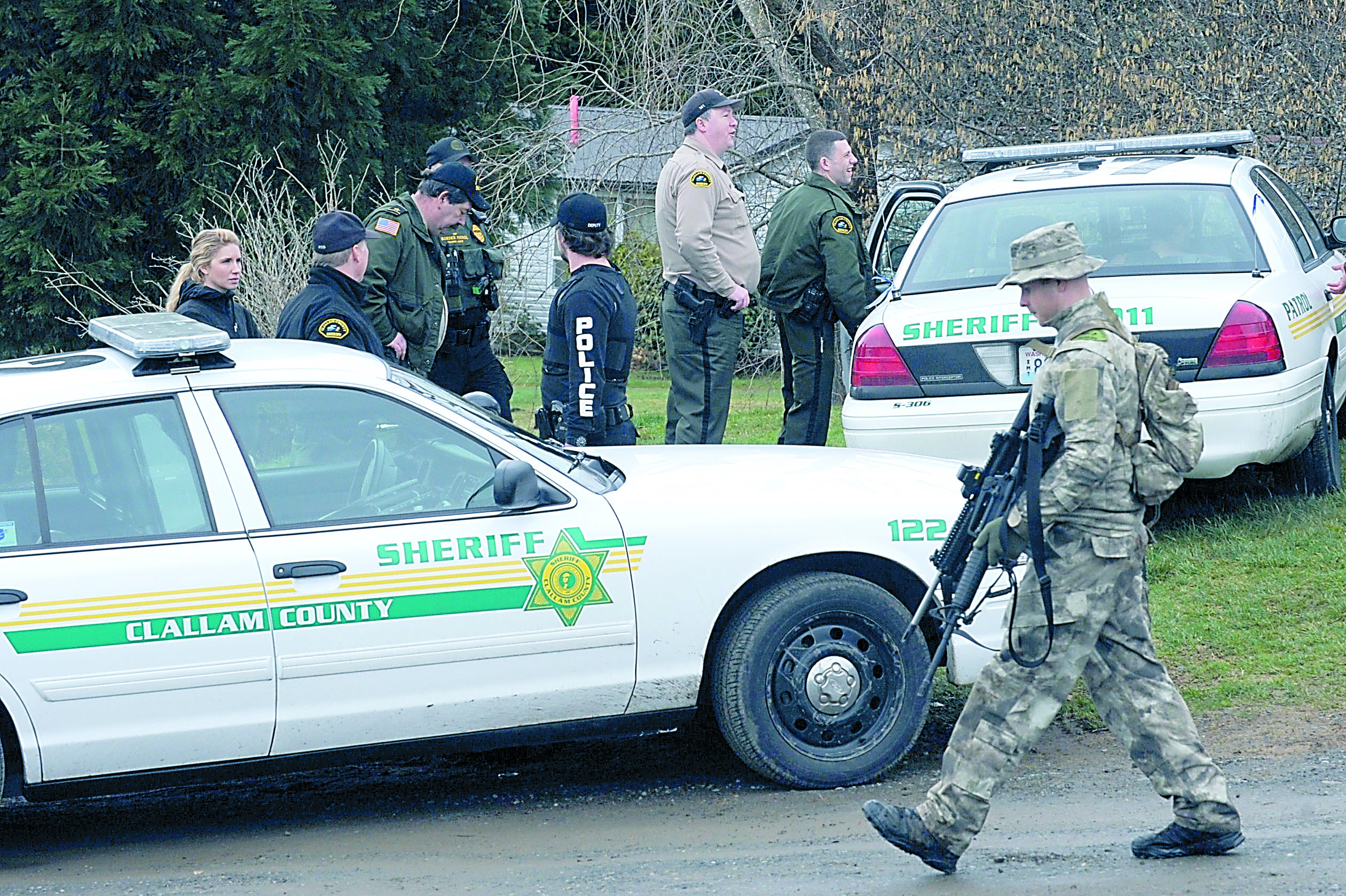 Law enforcement officers patrol the Snob Hill location of a suspect's residence along state Highway 112 west of Clallam Bay on Saturday. Lonnie Archibald/for Peninsula Daily News