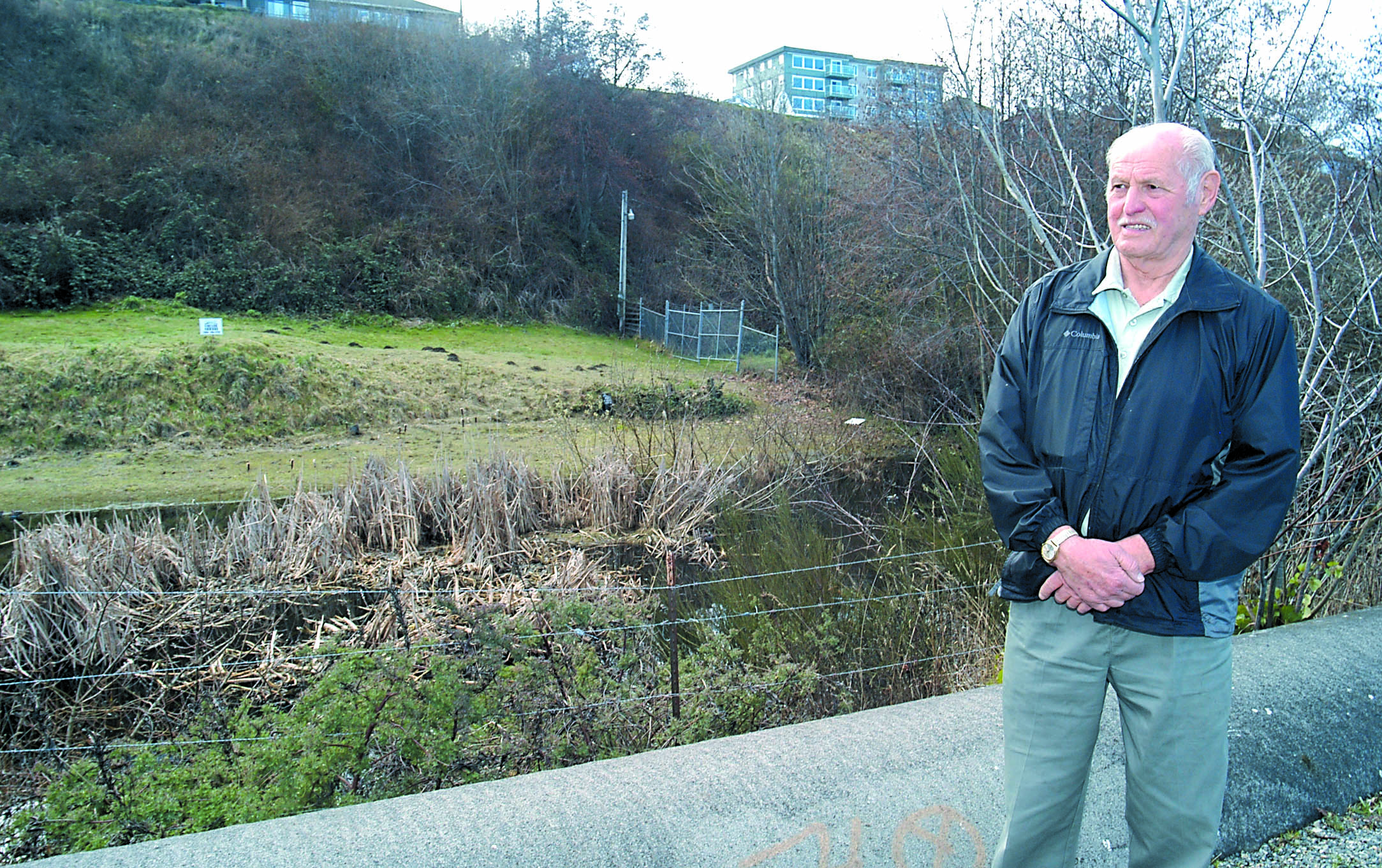 Jerry Austin stand on the Waterfront Trail next to several platted lots he owns and hopes to develop at the base of the bluff just east of the Red Lion Hotel in Port Angeles.  -- Photo by Keith Thorpe/Peninsula Daily News