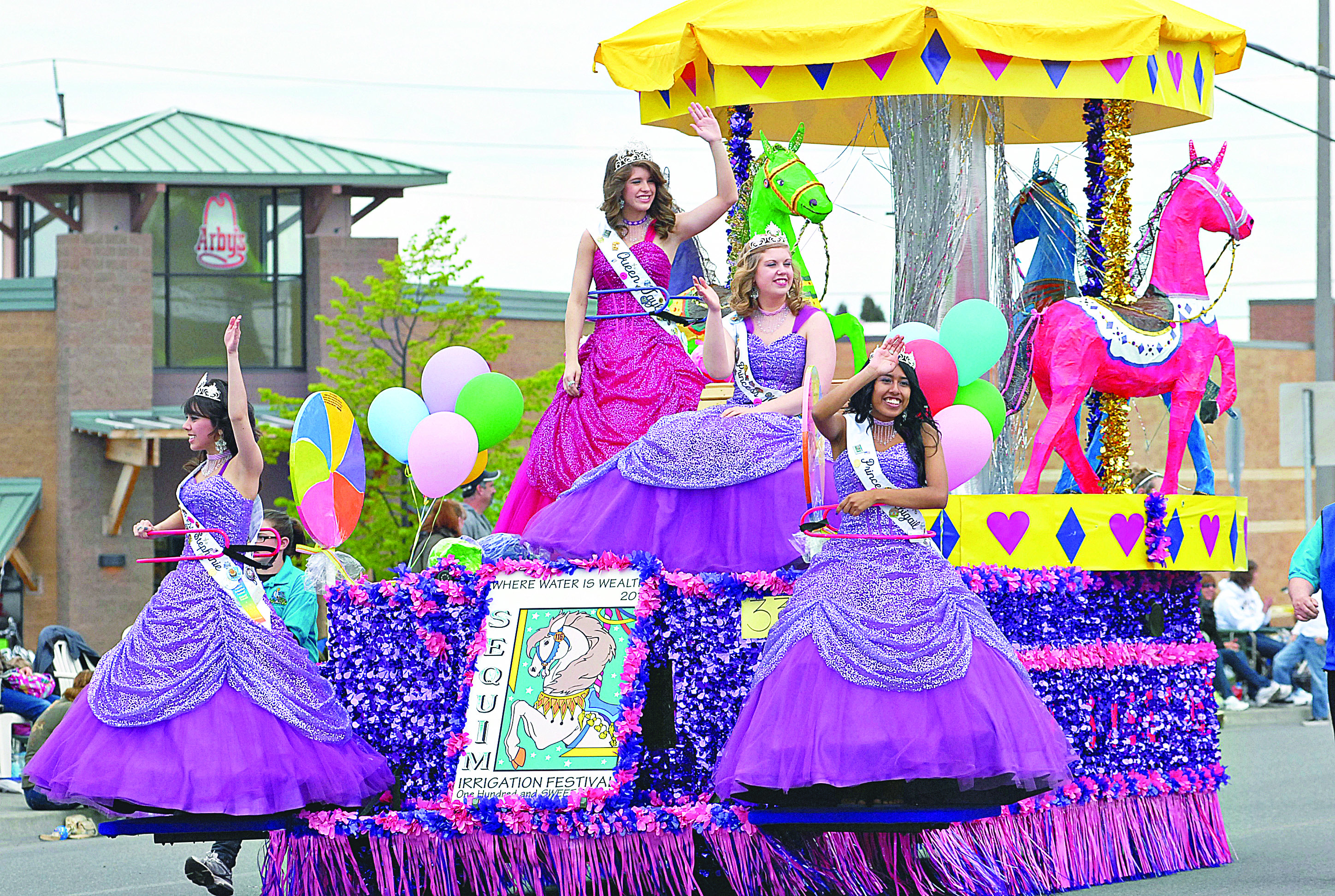 The Sequim Irrigation Festival parade float rolls down Washington Street in Sequim in 2011. From left are Princess Stephanie Laurie