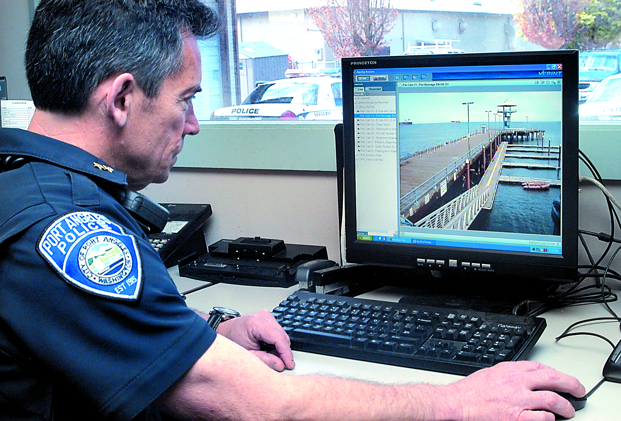 Deputy Police Chief Brian Smith looks at the view generated by a remote surveillance camera positioned on Port Angeles City Pier from the squad room at police headquarters.  -- Photo by Keith Thorpe/Peninsula Daily News