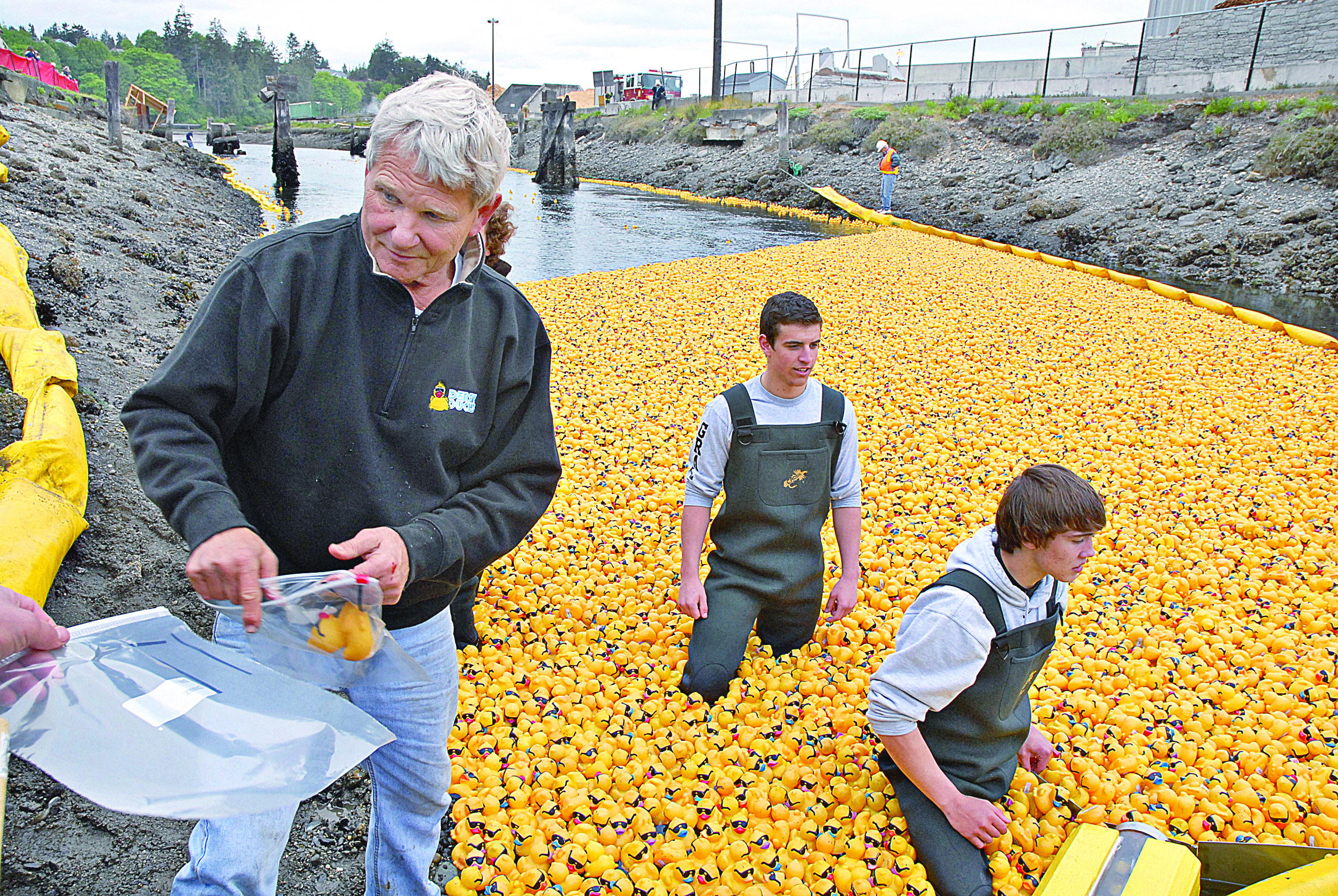 Bob Lovell bags one of the first 50 ducks that came across the finish line during the 22nd annual Great Olympic Peninsula Duck Derby in Port Angeles in 2011. At center is Zach Grall