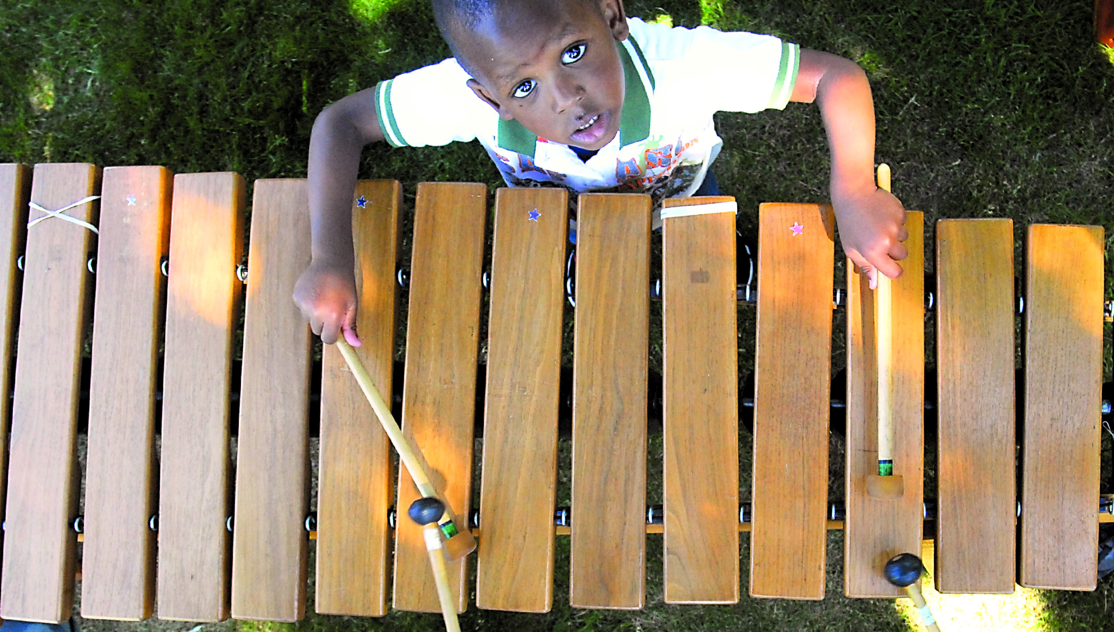 Three-year-old Gianni Vernet of Port Angeles tries his hand at playing a marimba prior to a performance by Sequimarimba on the front lawn of the Vern Burton Community Center in Port Angeles on Saturday. The center was the principal venue for the annual Juan de Fuca Festival of the Arts