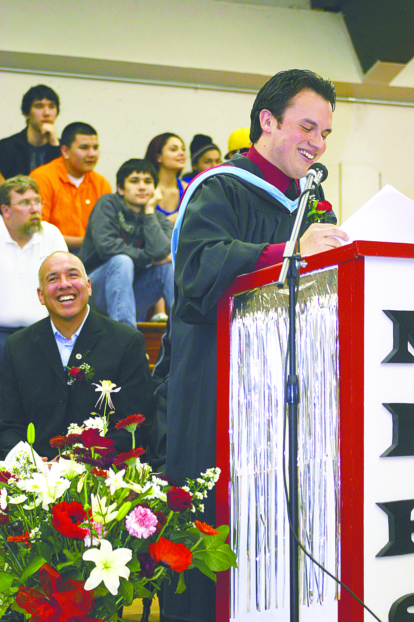 Commencement speaker Wilson Arnold praises the tenacity of his Neah Bay High School graduates during the June 2 ceremonies. Makah Tribal Council Vice Chairman Michael Lawrence is seated at left.  -- Photo by Diane Urbani de la Paz/Peninsula Profile