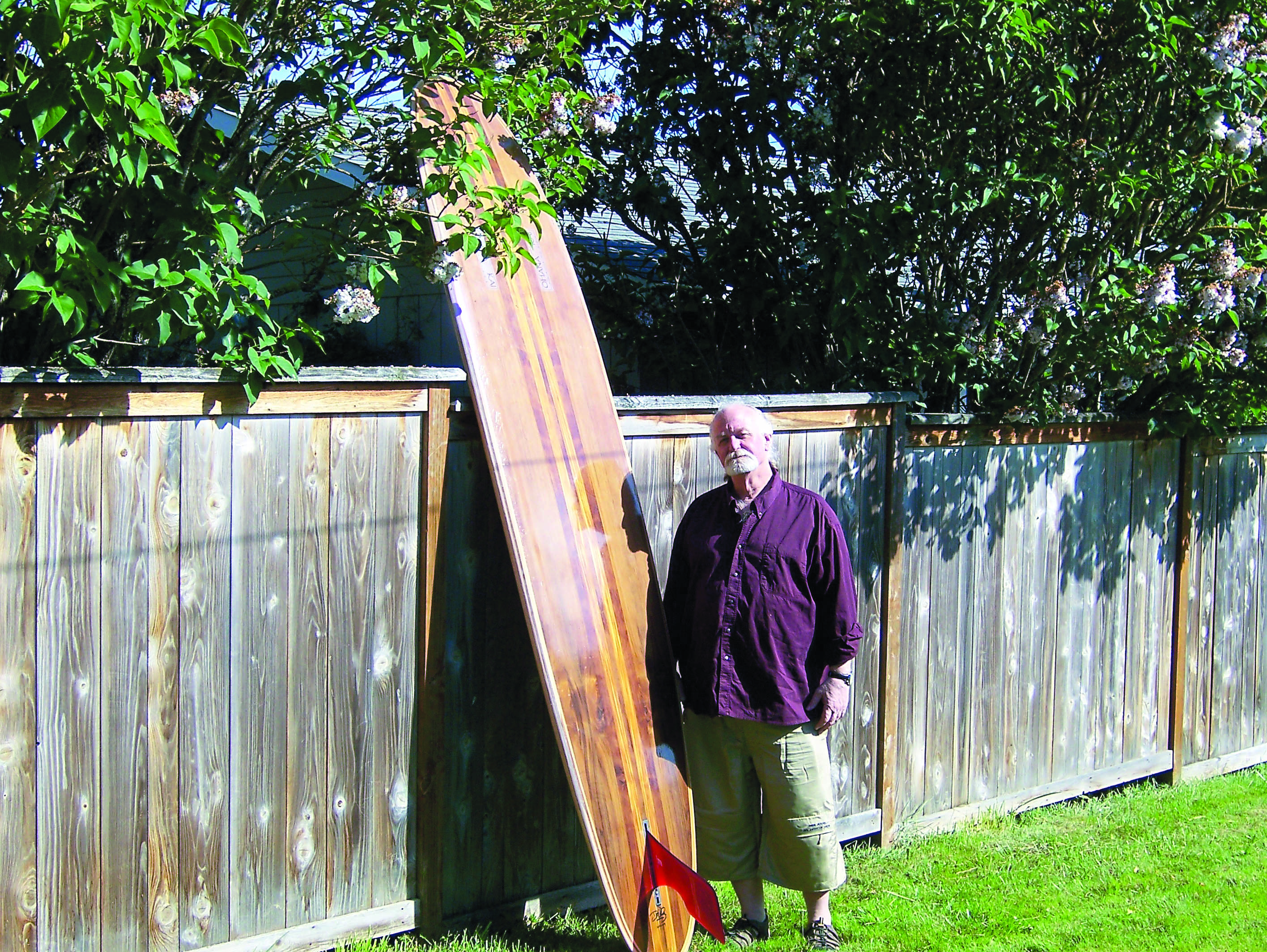 Durel Wiley stands with one of his 10-foot longboard creations in Port Angeles.  -- Photo by David G. Sellars/Peninsula Daily News