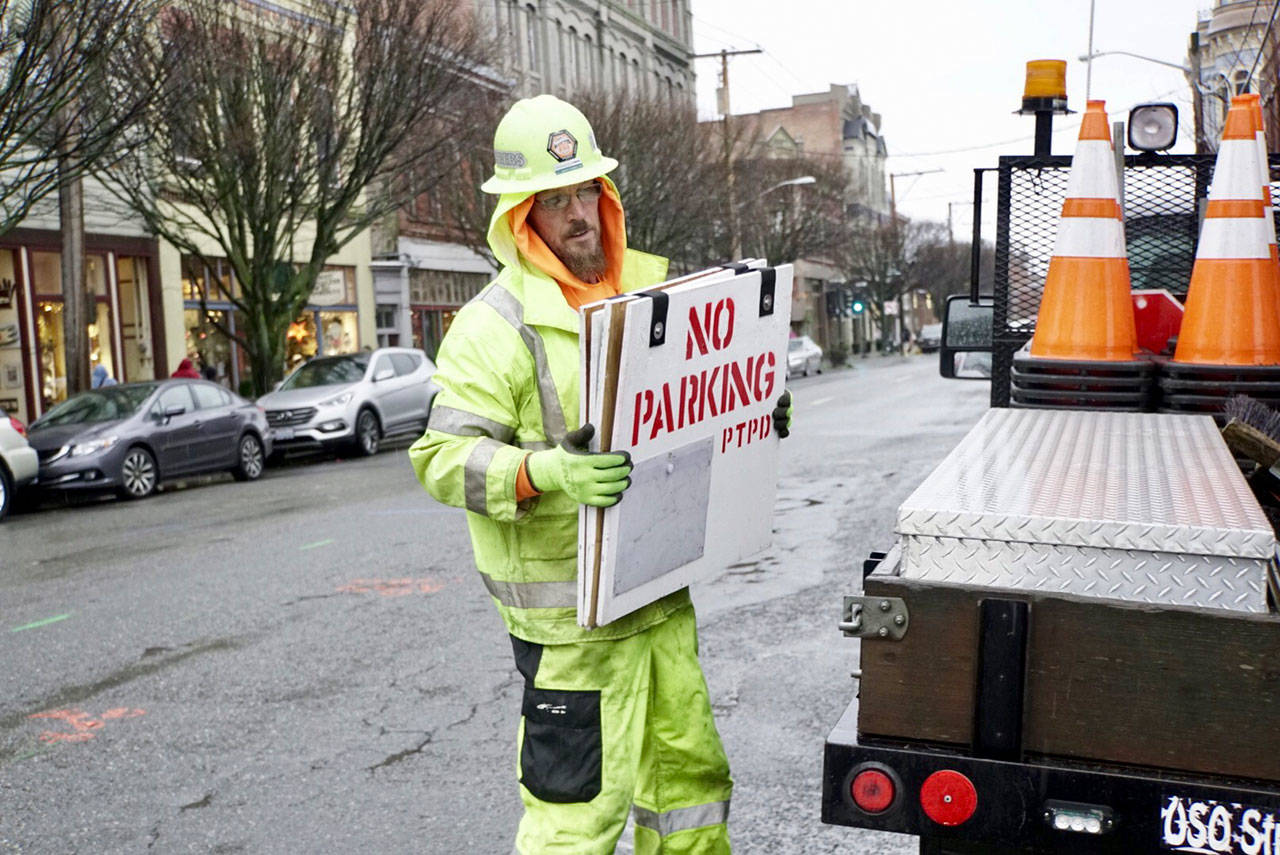 Tim Childs, traffic control supervisor for Interwest Construction in Carlsborg, places no parking signs along Water Street in downtown Port Townsend on Friday. On Tuesday, the company will start a project that includes replacing sewer lines and placing power lines underground. (Steve Mullensky/for Peninsula Daily News)