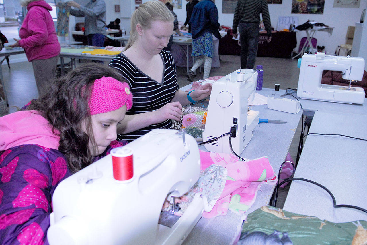 MiAmada Lamphear, 12, and Katie Bailey, 19 — who was on break from classes at Idaho State University — put their sewing skills to work for the sake of animals. Their work helped create pet beds for local animal shelters during a volunteer afternoon in Port Hadlock. (Jeannie McMacken/for Peninsula Daily News)