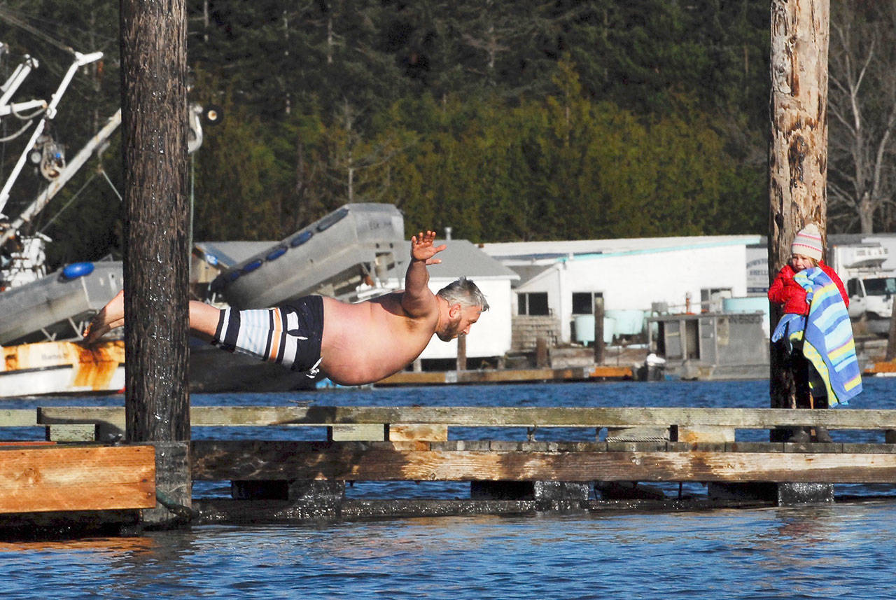 Zach Devos launches for a belly flop in the Nordland polar bear dip across from the Nordland General Store on Monday. (Jeannie McMacken/for Peninsula Daily News)