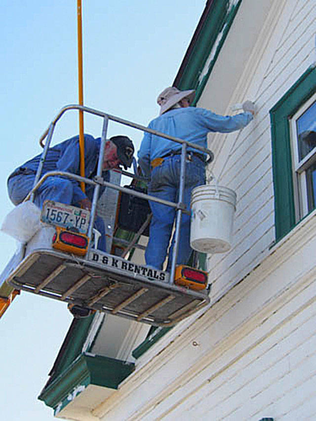An all-volunteer group takes part in a recent work party, prepping one of the buildings at the New Dungeness Lighthouse for a fresh coat of paint.