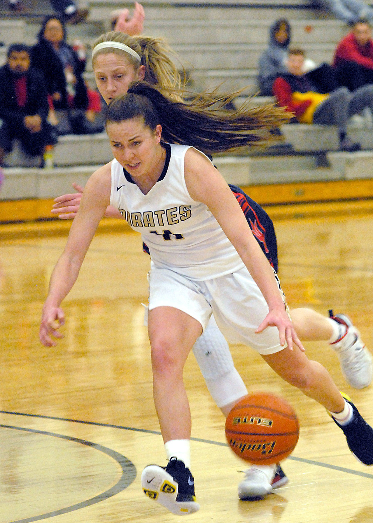 Keith Thorpe/Peninsula Daily News Peninsulas Ashlynn Sharp, front, drives past Lower Columbias Shanay Dotson in the first quarter on Friday on the Pirate home court in Port Angeles.