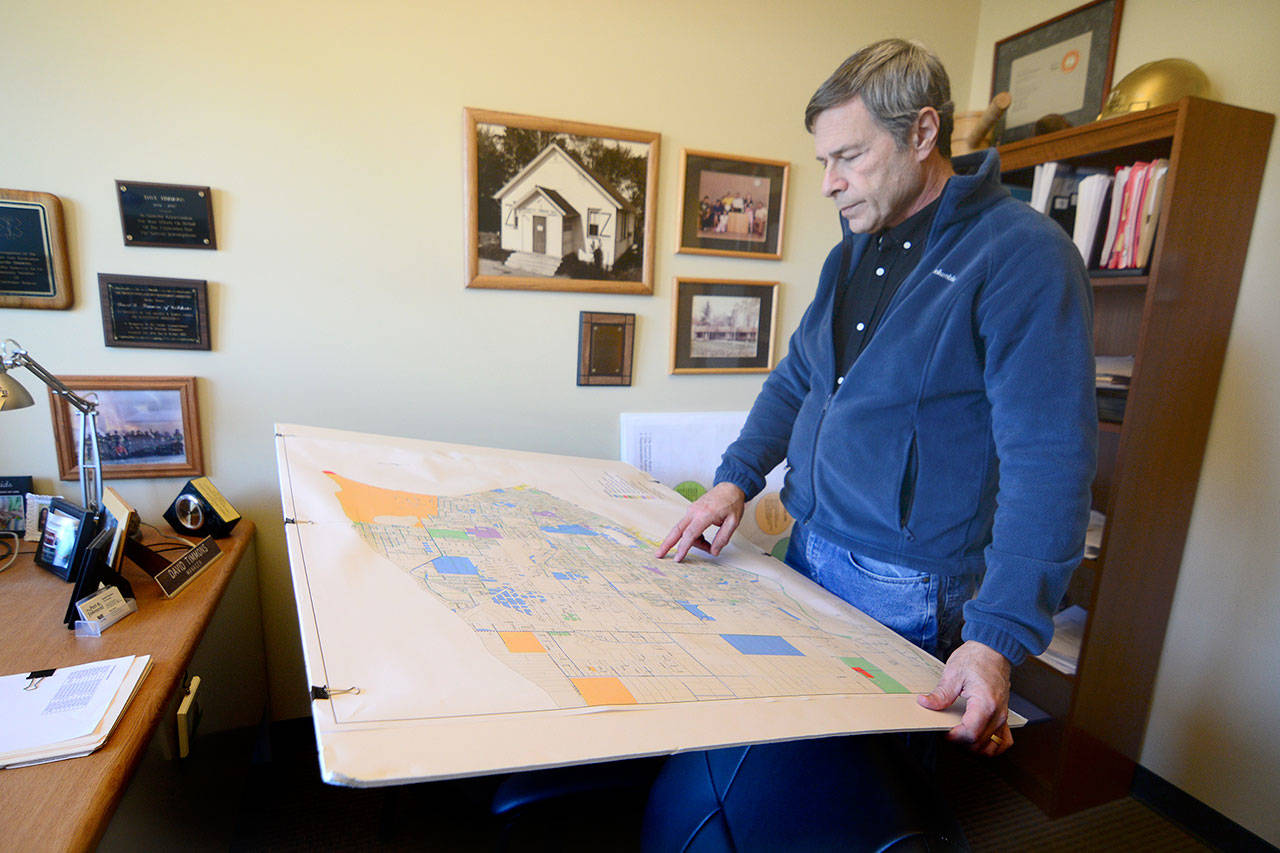 David Timmons looks for “shovel ready” parcels on a map of Port Townsend as he looks for solutions to the city’s housing shortage. Timmons told the City Council on Monday that he is prepared to delay his retirement — originally slated for the end of 2018 — for six months in an effort to smooth the transition between him and his successor. (Jesse Major/Peninsula Daily News)