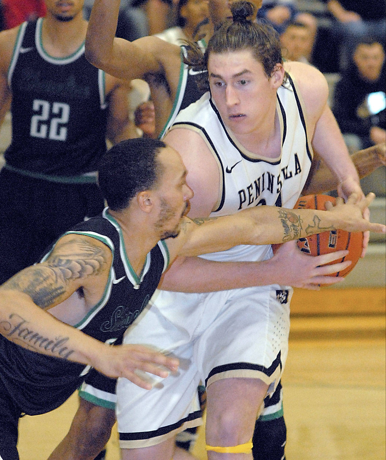 Keith Thorpe/Peninsula Daily News Peninsula’s Marky Adams, right, fends of the defense of Shoreline’s Darnell Berry on Wednesday in Port Angeles.
