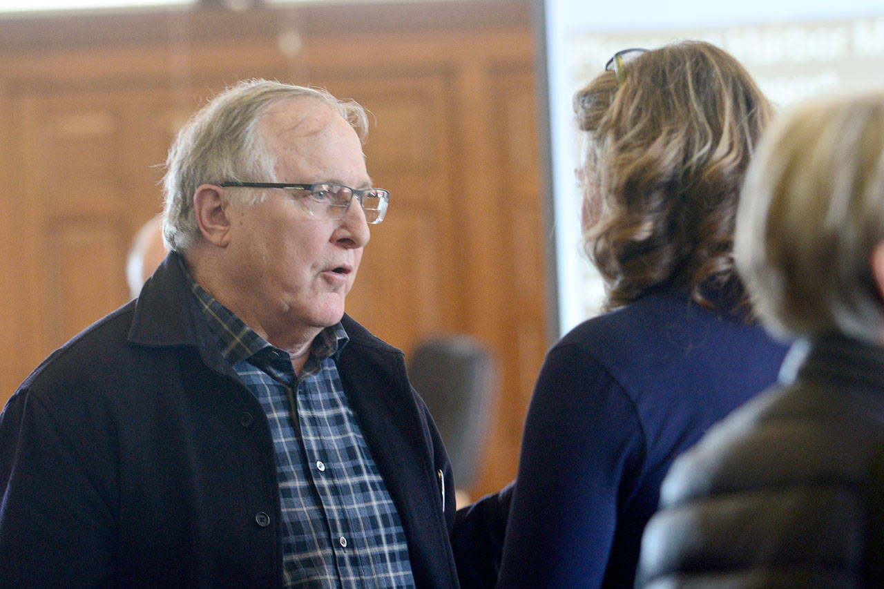 Peter Newland, who represents the Tarboo Ridge Coalition — a group of homeowners opposed to Joe D’Amico’s proposed shooting range — talks with Jefferson County Commissioner Kate Dean on Tuesday. (Jesse Major/Peninsula Daily News)