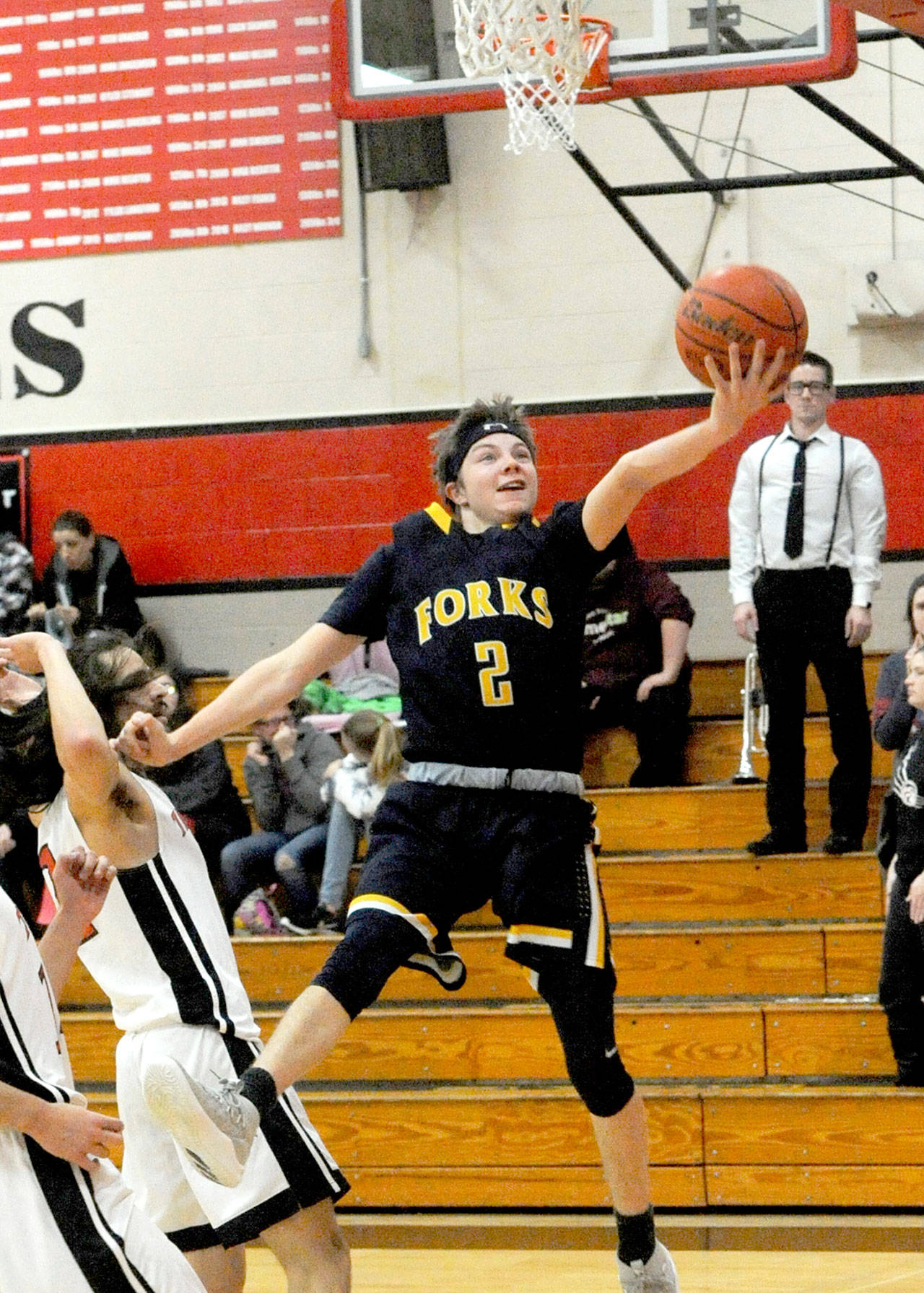 Forks’ Joseph Reaume scores around the defense of Tenino’s Tony Canepa during the Spartans’ 62-28 victory Tuesday.                                Lonnie Archibald/for Peninsula Daily News