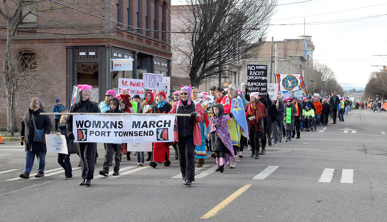 Joy Beaver, left and Berit Guerin, both from Sequim where honored to lead the parade as banner carriers. According to Port Townsend police, there were almost 4,000 participants in the Port Townsend Women’s March that snaked along an under-construction Water Street. (Jeannie McMacken/for Peninsula Daily News)