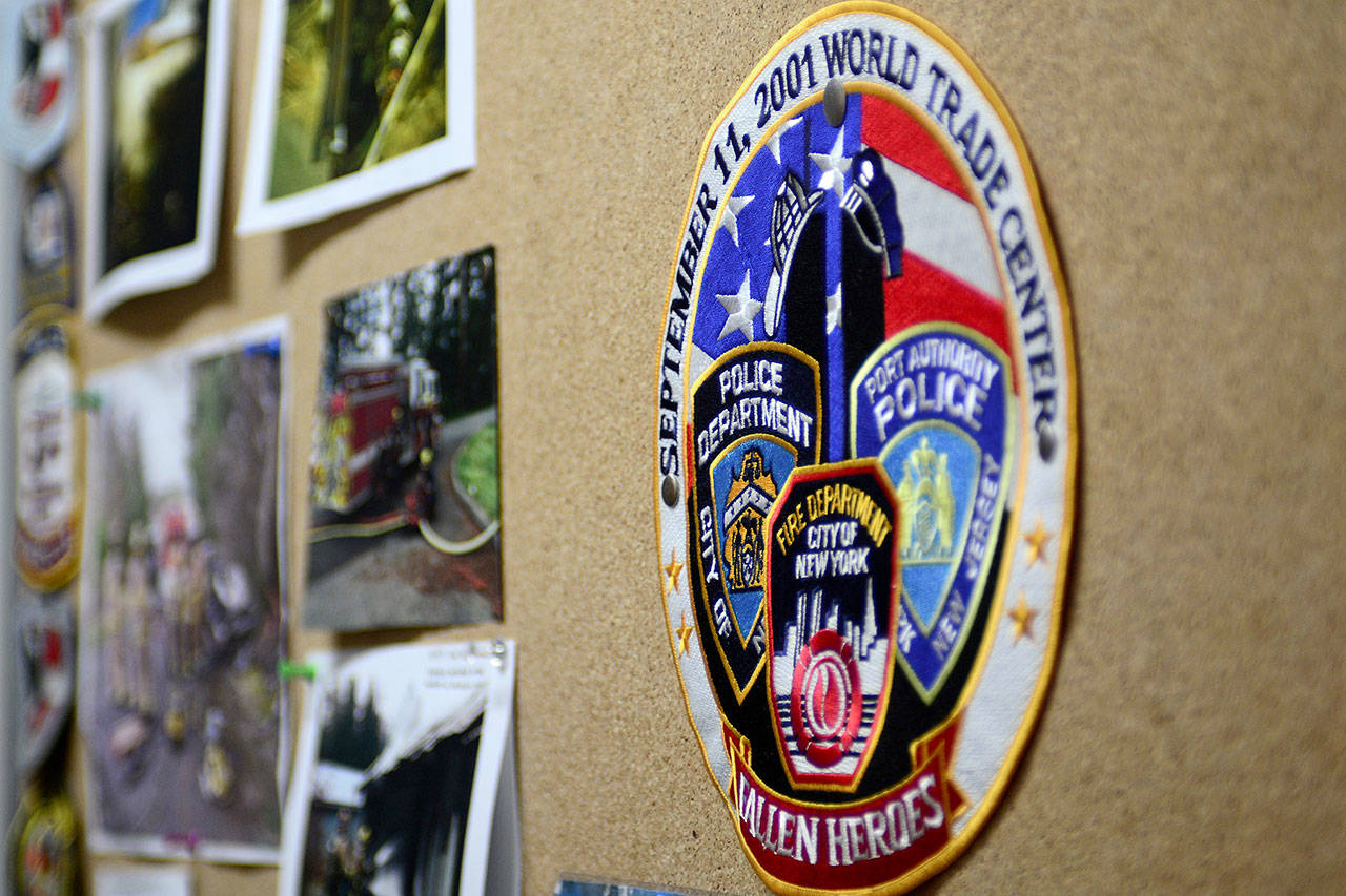 A patch honoring first responders who died following the 9/11 terrorist attacks sits at the center of a photo display at Naval Magazine Indian Island’s fire station. (Jesse Major/Peninsula Daily News)