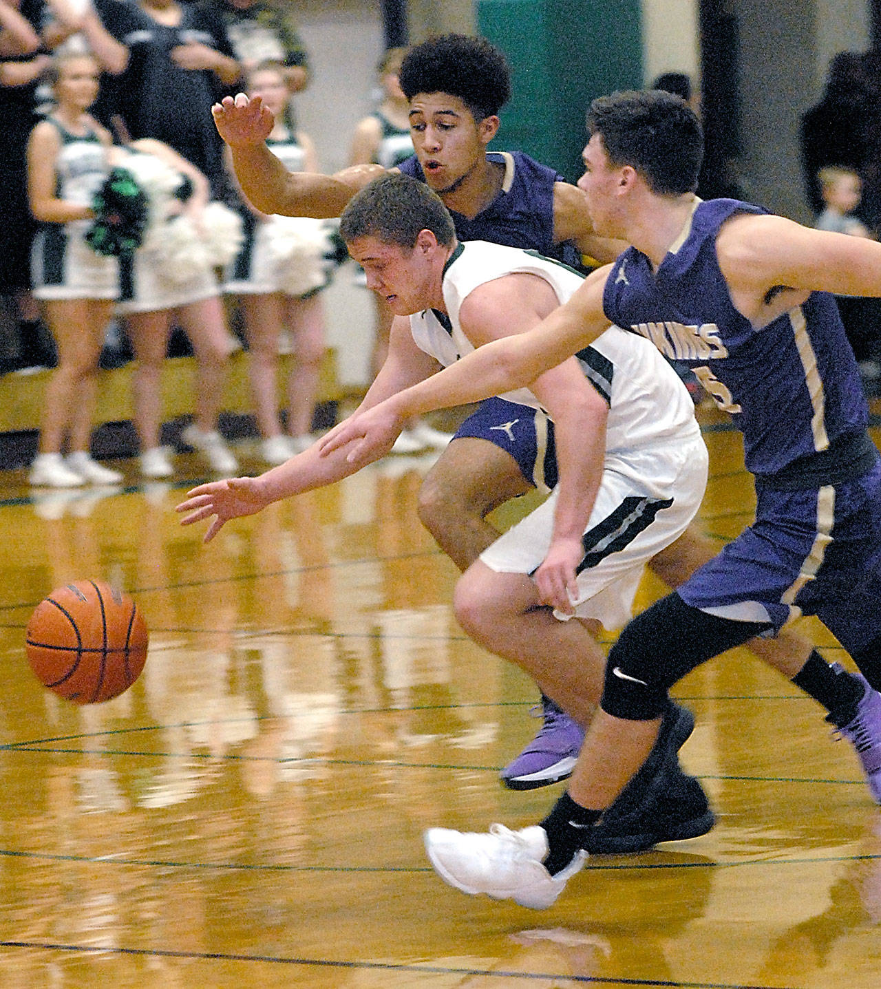 Port Angeles’ Easton Joslin, center, tries to outrun North Kitsap’s Kai Warren, left, and Ryan Hecker in the second quarter on Tuesday night at Port Angeles High School.                                Keith Thorpe/Peninsula Daily News