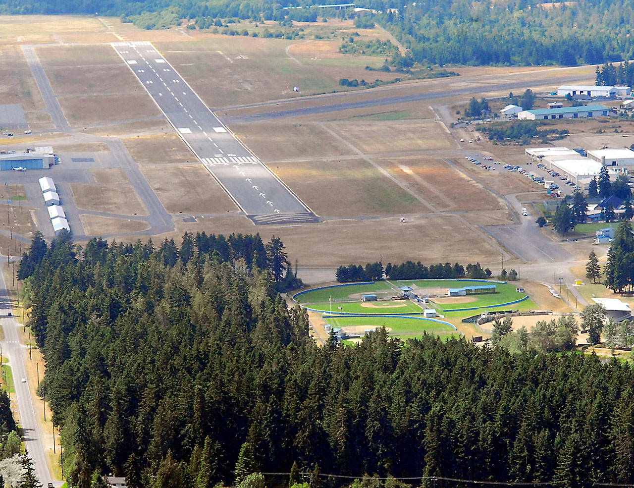 The 6,347-foot long main runway at William R. Fairchild International Airport in Port Angeles, known officially as 8/26, is shown in this July 2011 file photo. The heavily-forested Lincoln Park with its athletic fields is shown at bottom. (Keith Thorpe/Peninsula Daily News)
