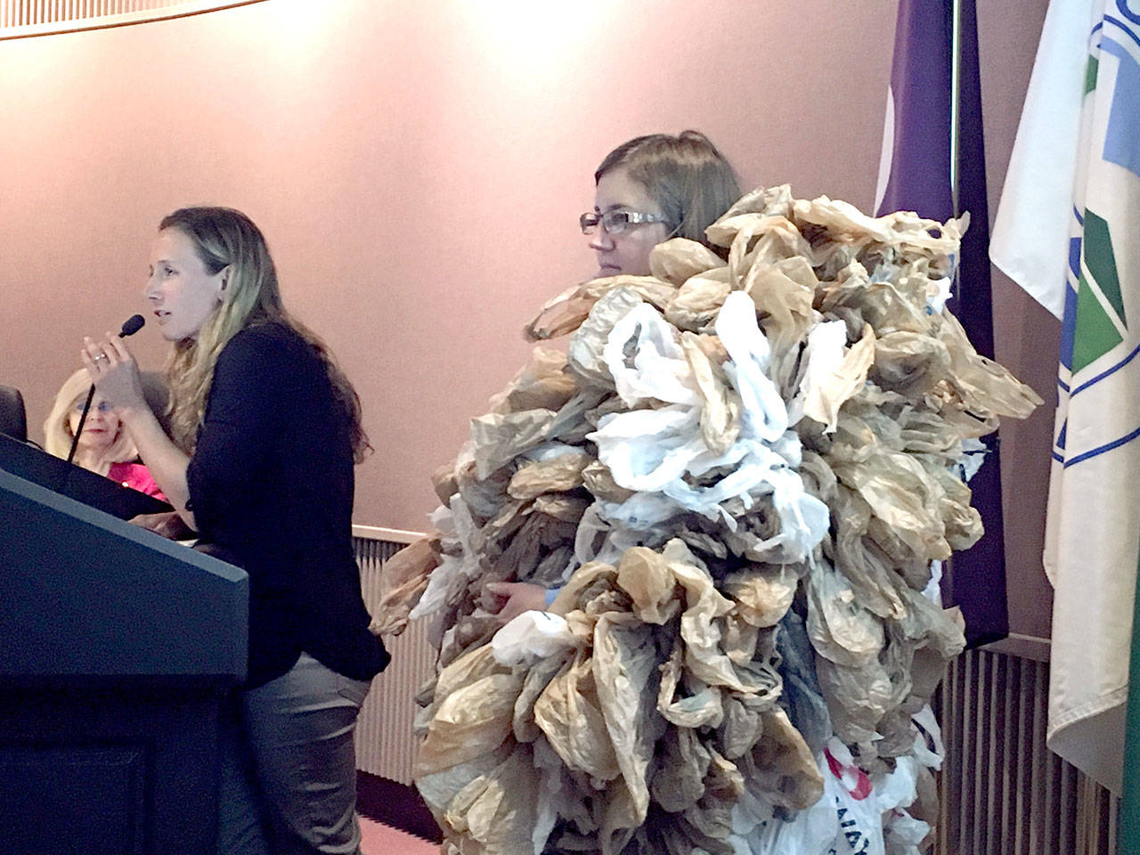 Melinda Gelder of the Port Angeles Plastic Reduction Coalition speaks to the Port Angeles City Council on Tuesday as Kim Sager-Fradkin looks on. Sager-Fradkin was wearing a costume of 500 plastic bags to represent the number of plastic bags that the average American throws away every year. (Rob Ollikainen/Peninsula Daily News)