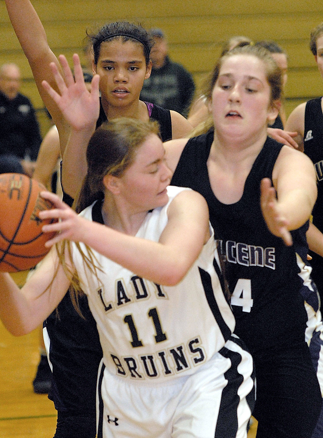Clallam Bay’s Hannah Olson, center, fends off the defensive efforts of Quilcene’s Marissa Kieffer, right, and Gina Brown, back, in the first quarter of their Class 1B Tri-District Tournament loser-out girls basketball playoff game Saturday night at Port Angeles High School.                                (Keith Thorpe/Peninsula Daily News)