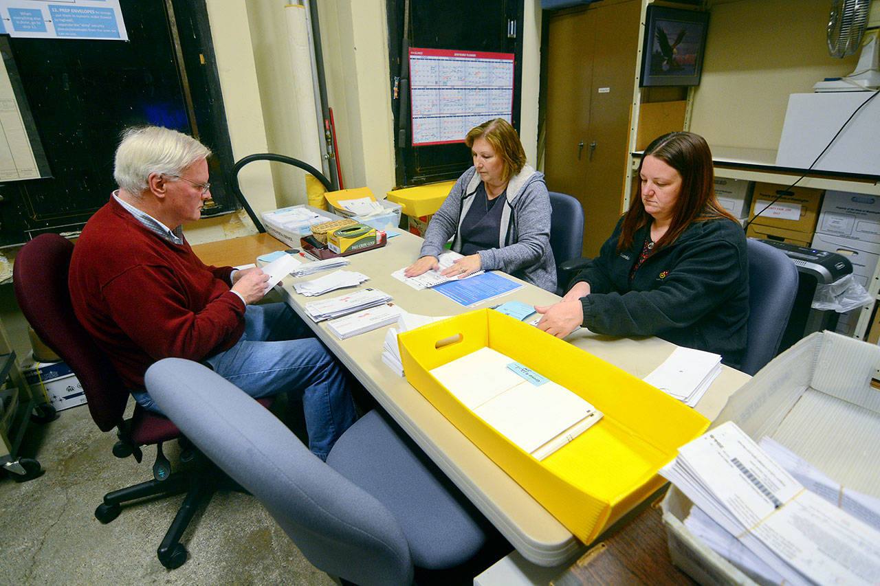 From left, Jefferson County election board worker Jay Page, Election Coordinator Betty Johnson and county licensing agent Barb Ferguson process ballots Friday. (Jesse Major/Peninsula Daily News)