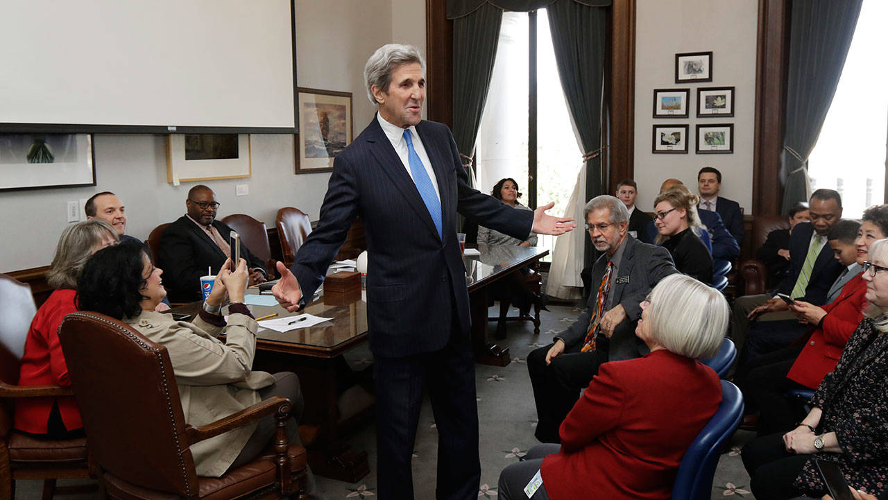 Former Secretary of State John Kerry greets members of the House Democratic Caucus on Tuesday during a visit hosted by Gov. Jay Inslee to participate in meetings discussing the governor’s proposed tax on fossil fuel emissions. (Ted S. Warren/The Associated Press)