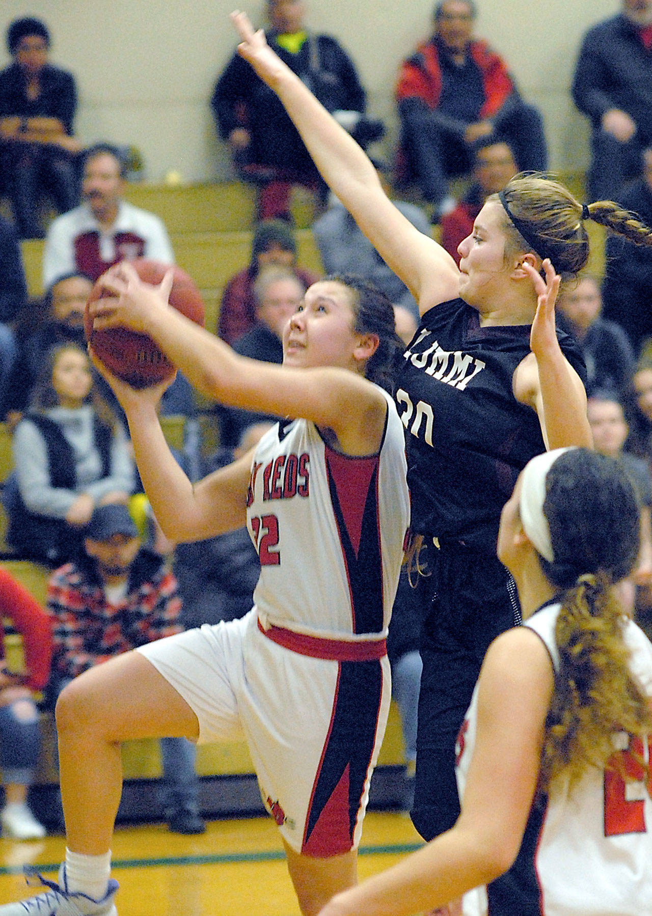 Neah Bay’s Ruth Moss, left, goes for a layup as Lummi’s Shelby Jacobs defends the lane in the third quarter on Tuesday night in Port Angles. In the forground is Moss’s teammate, Patience Swan.                                Keith Thorpe/Peninsula Daily News