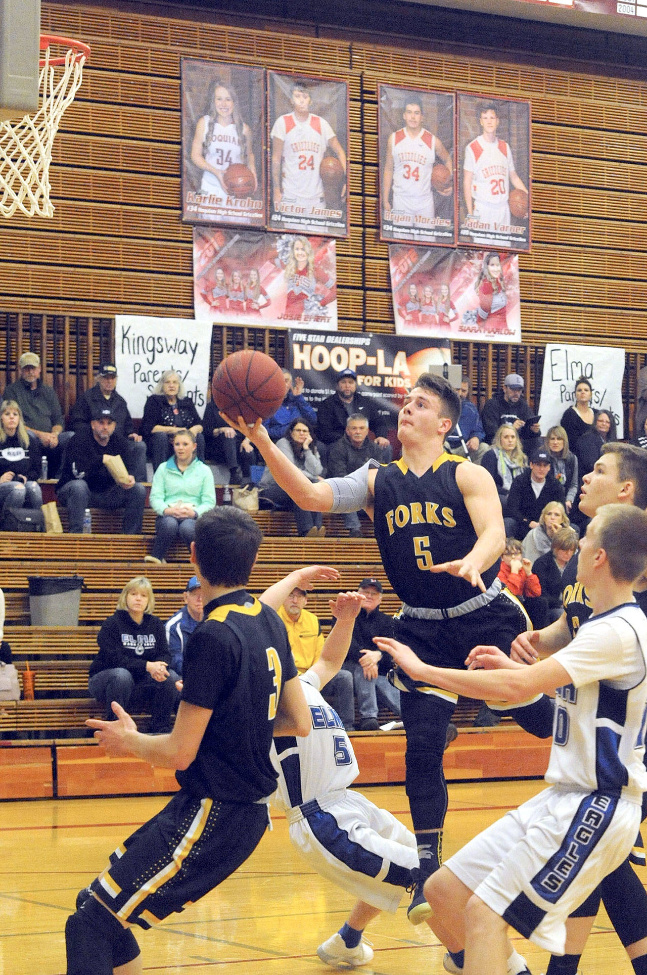 Forks’ Cole Baysinger (5) drives the lane and scores against Elma during the Spartans’ win onTuesday evening in Hoquiam.                                Lonnie Archibald /for Peninsula Daily News