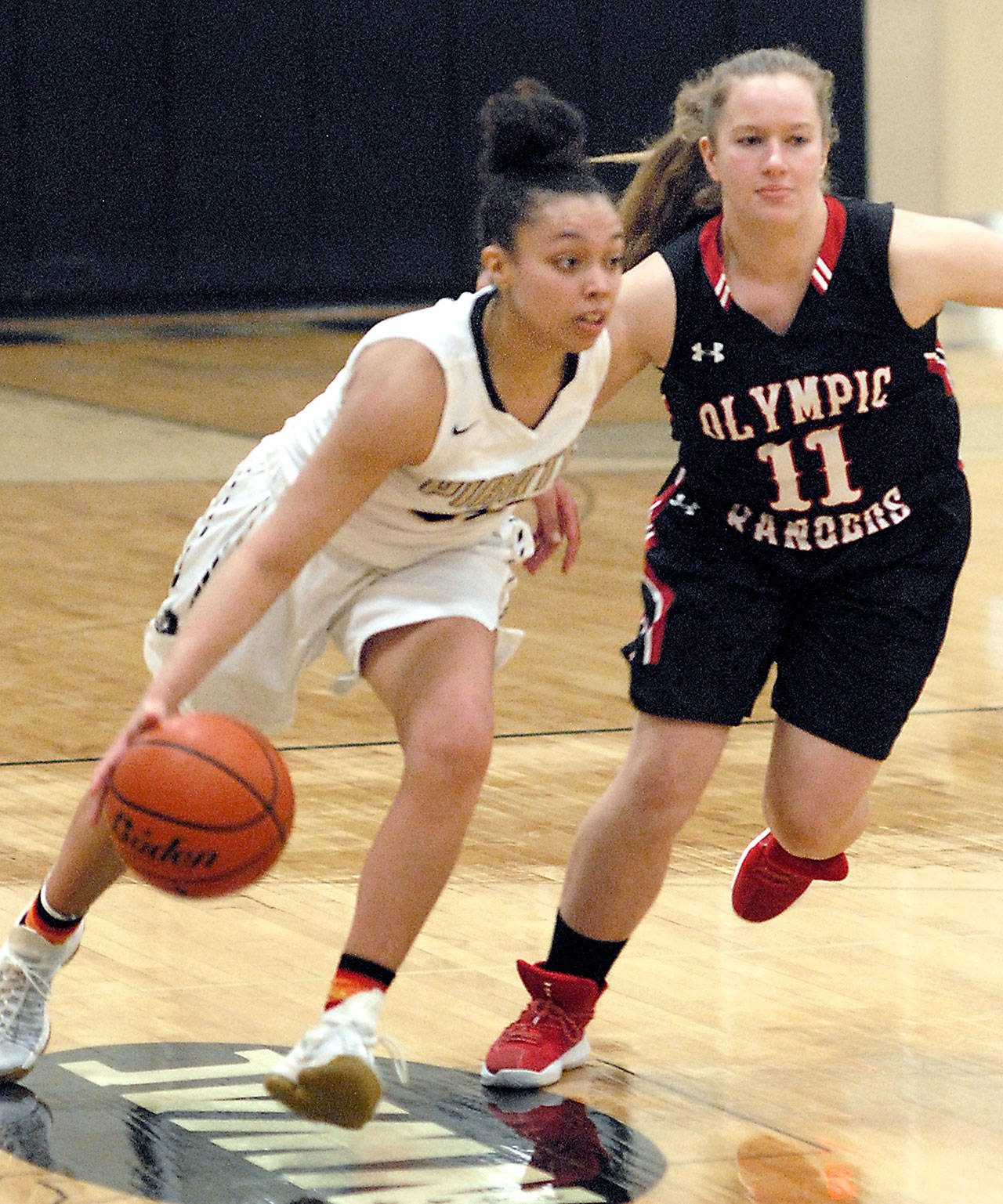 Peninsula’s Tiffany Smith, left, drives downcourt while guarded by Olympic’s Shanya Nisbet, a Chimacum graduate, Wednesday in Port Angeles.                                Keith Thorpe/Peninsula Daily News