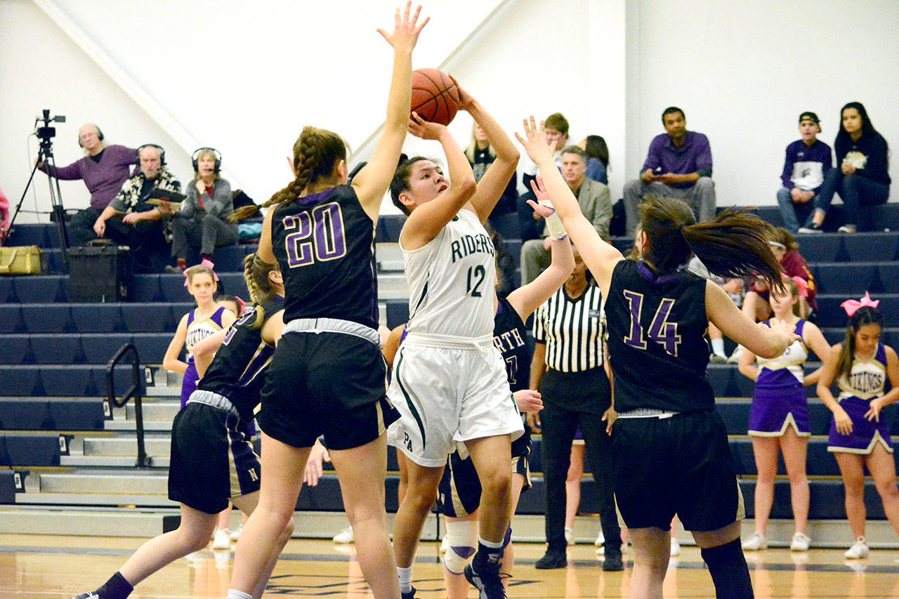 Mark Krulish/Kitsap News Group Port Angeles’ Cheyenne Wheeler puts up a jumper in traffic while defended by North Kitsap’s Erin Pearson (20) and Noey Barreith (14) during the Riders’ district semifinal win.